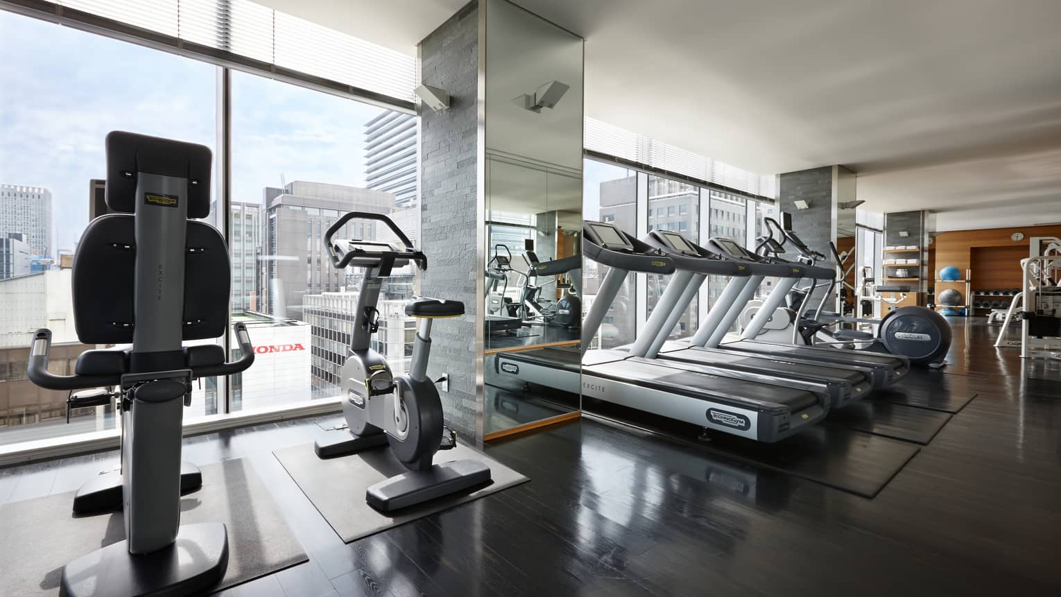 Elliptical machines, treadmills, cardio equipment by sunny window in Fitness Centre