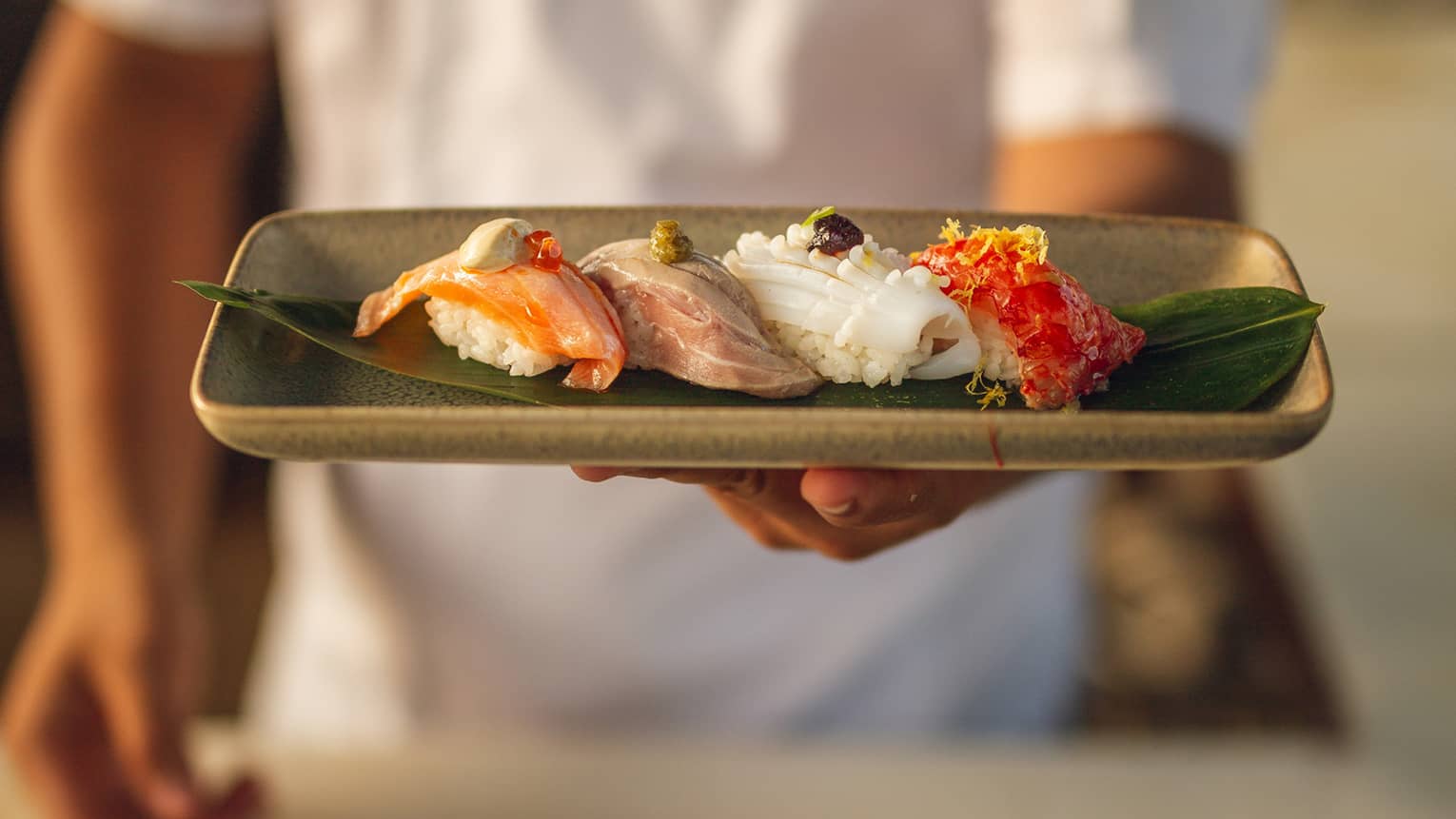 Chef holds a platter of nigiri selection