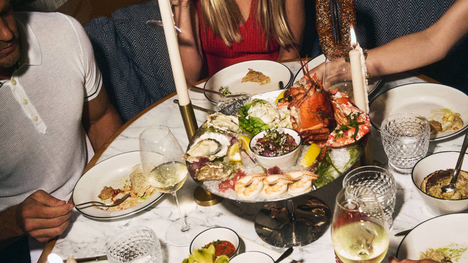 Oval table filled with large dinner spread including a seafood tray and more