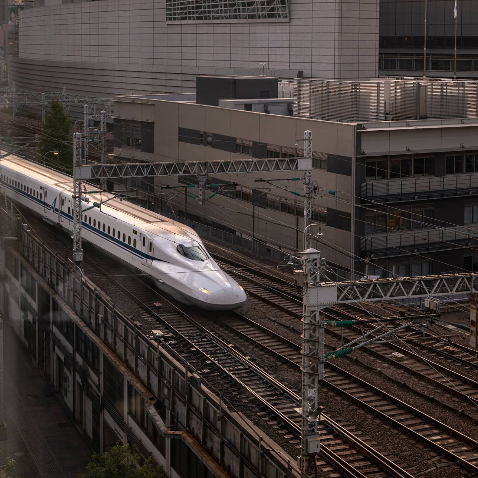 Shinkansen bullet train arrives at the station at sunset