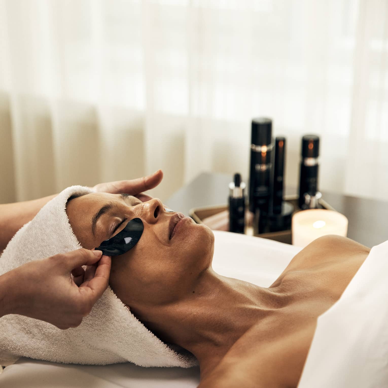 A woman getting a facial treatment in a well lit spa.