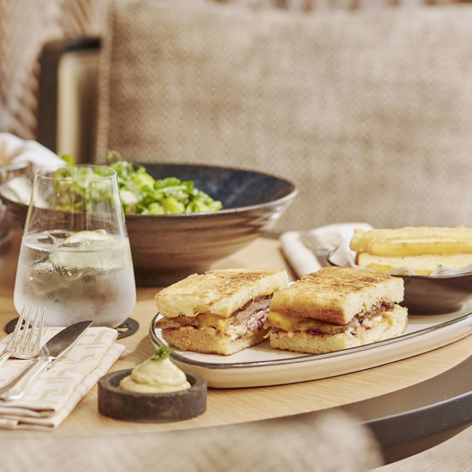 An assortment of pasta, salad and sandwiches on a small table.