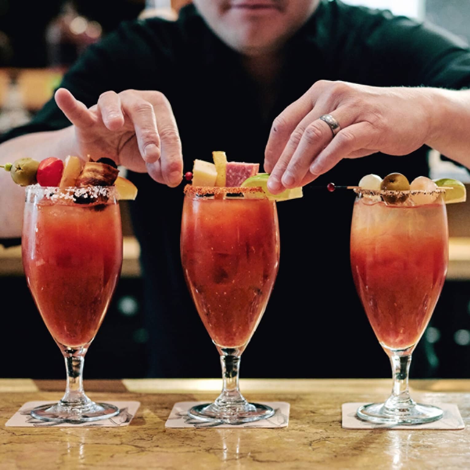 A row of four Bloody Marry’s being garnished.