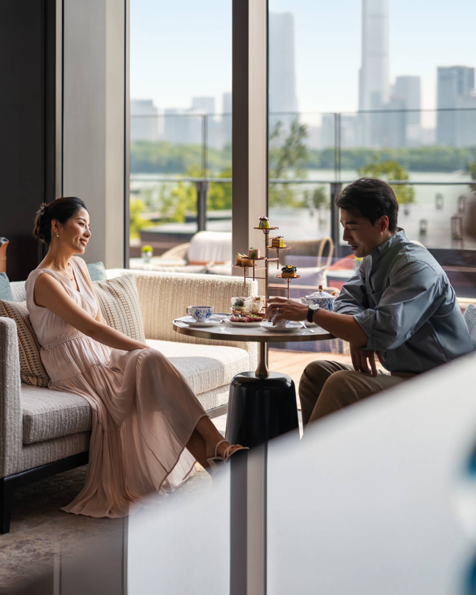 Man and woman enjoy afternoon tea at Lobby Lounge at luxury hotel
