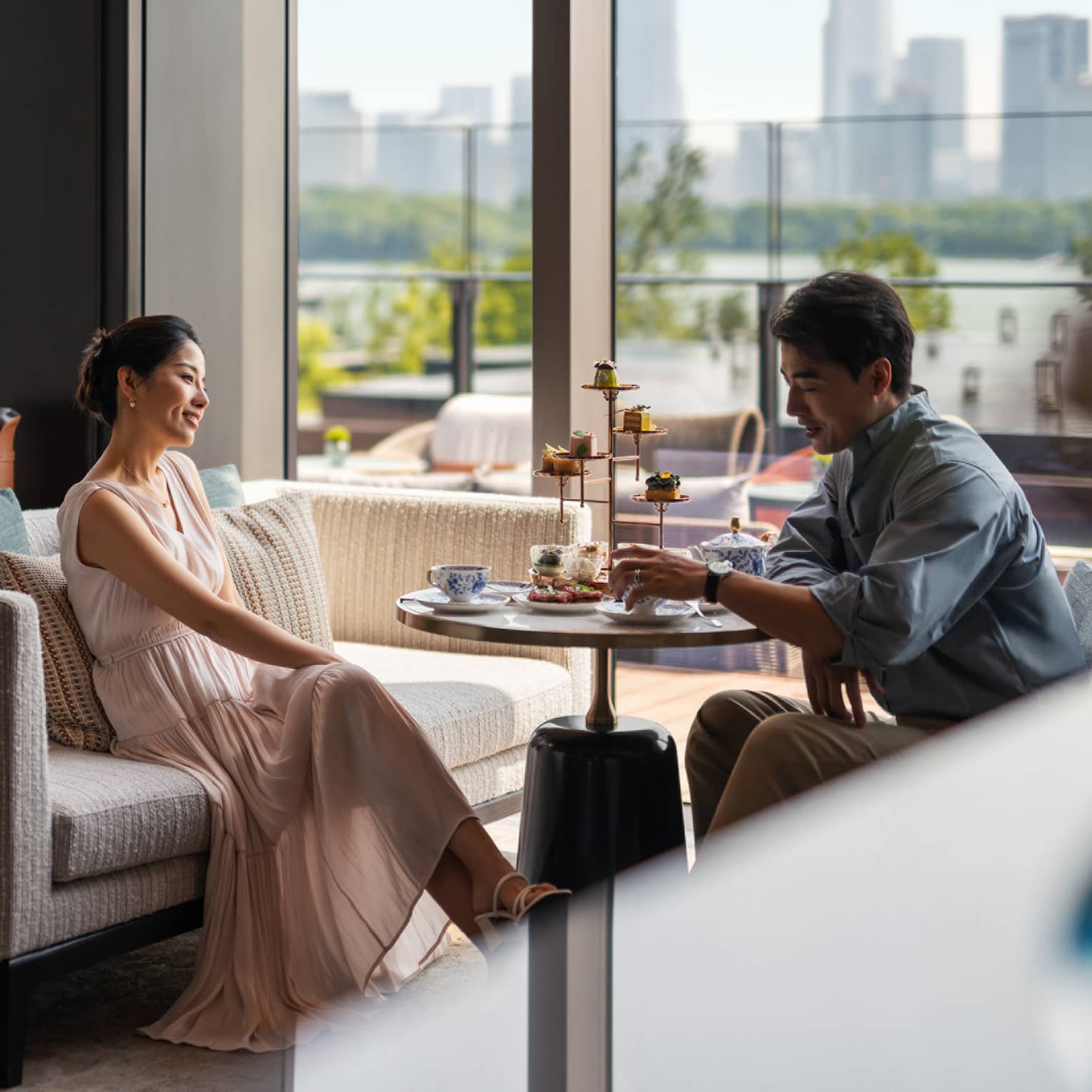 Man and woman enjoy afternoon tea at Lobby Lounge at luxury hotel