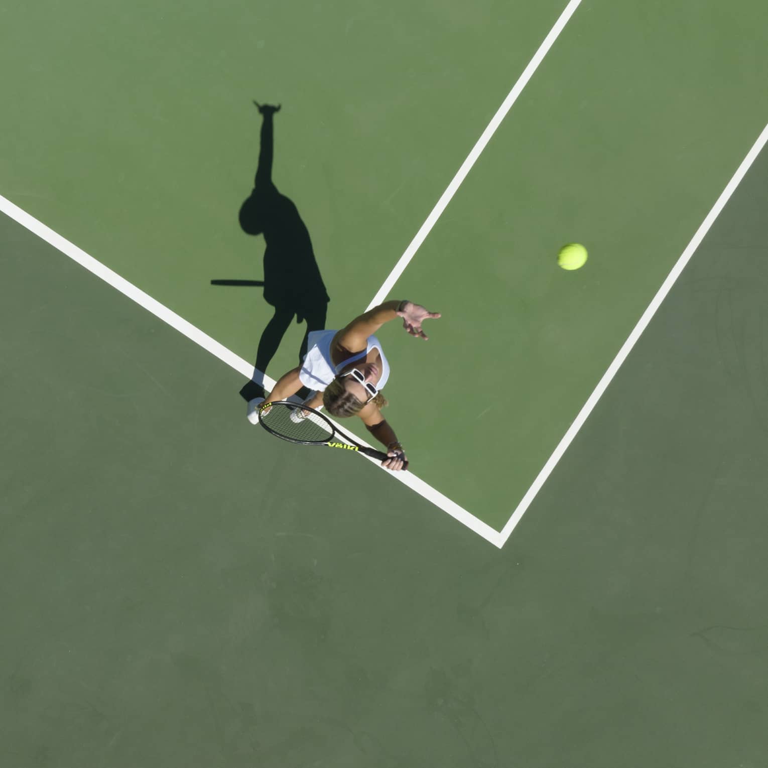 Aerial view of a tennis player mid serve