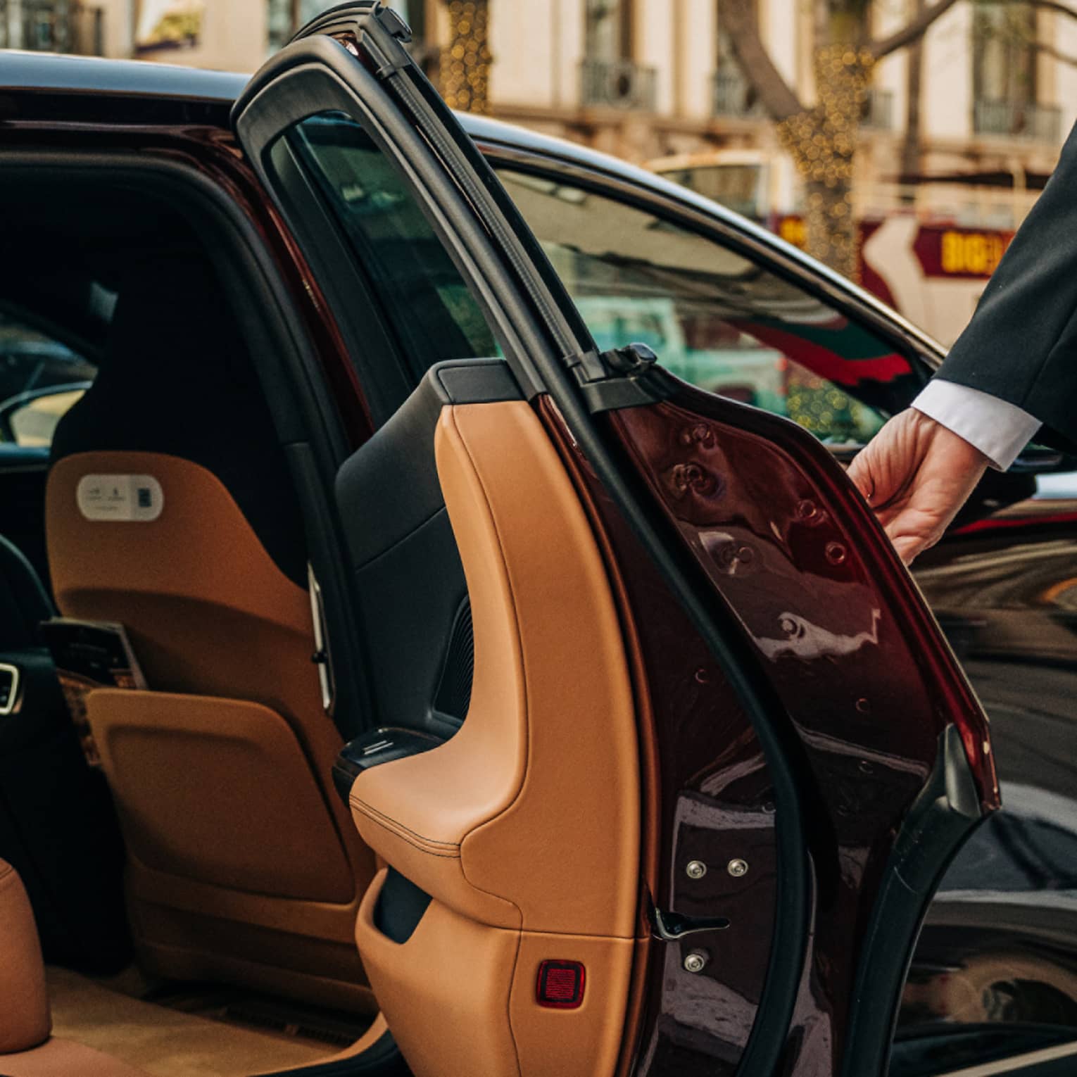 Person wearing a suit and opening a car door