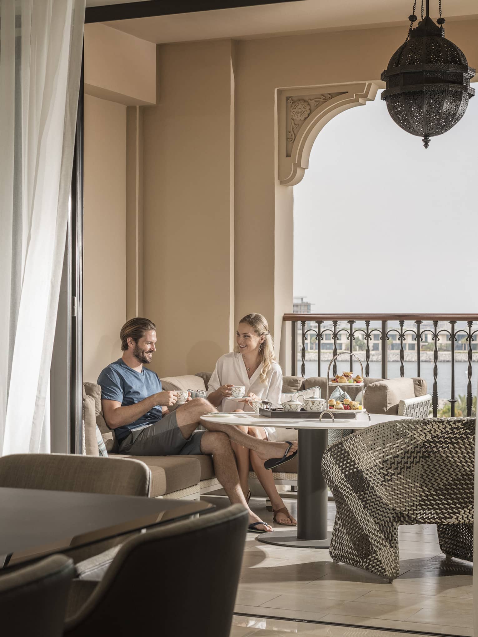 Hotel suite dining table in front of couple enjoying breakfast on covered balcony
