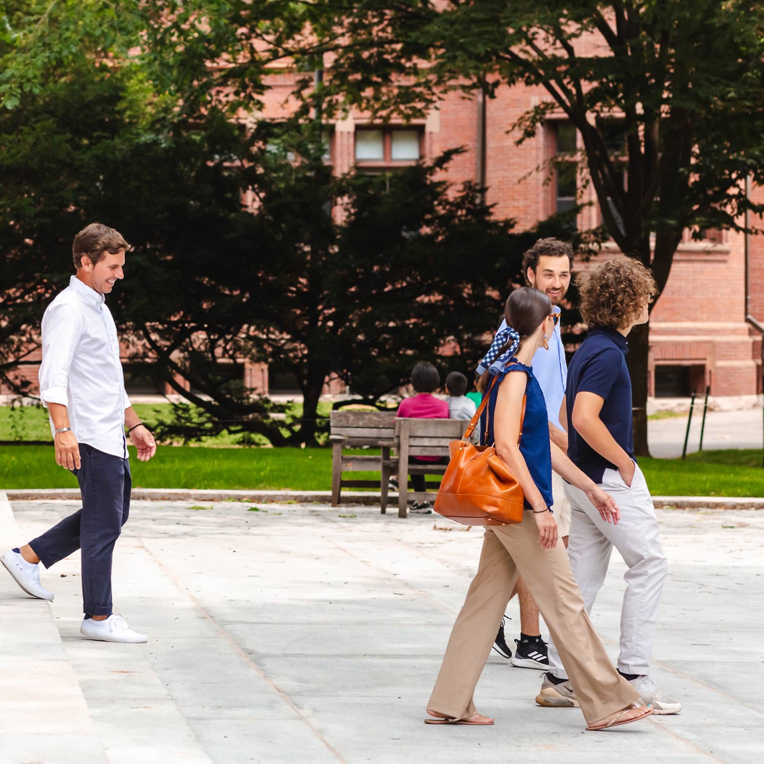 A family walking down steps in a park like area.