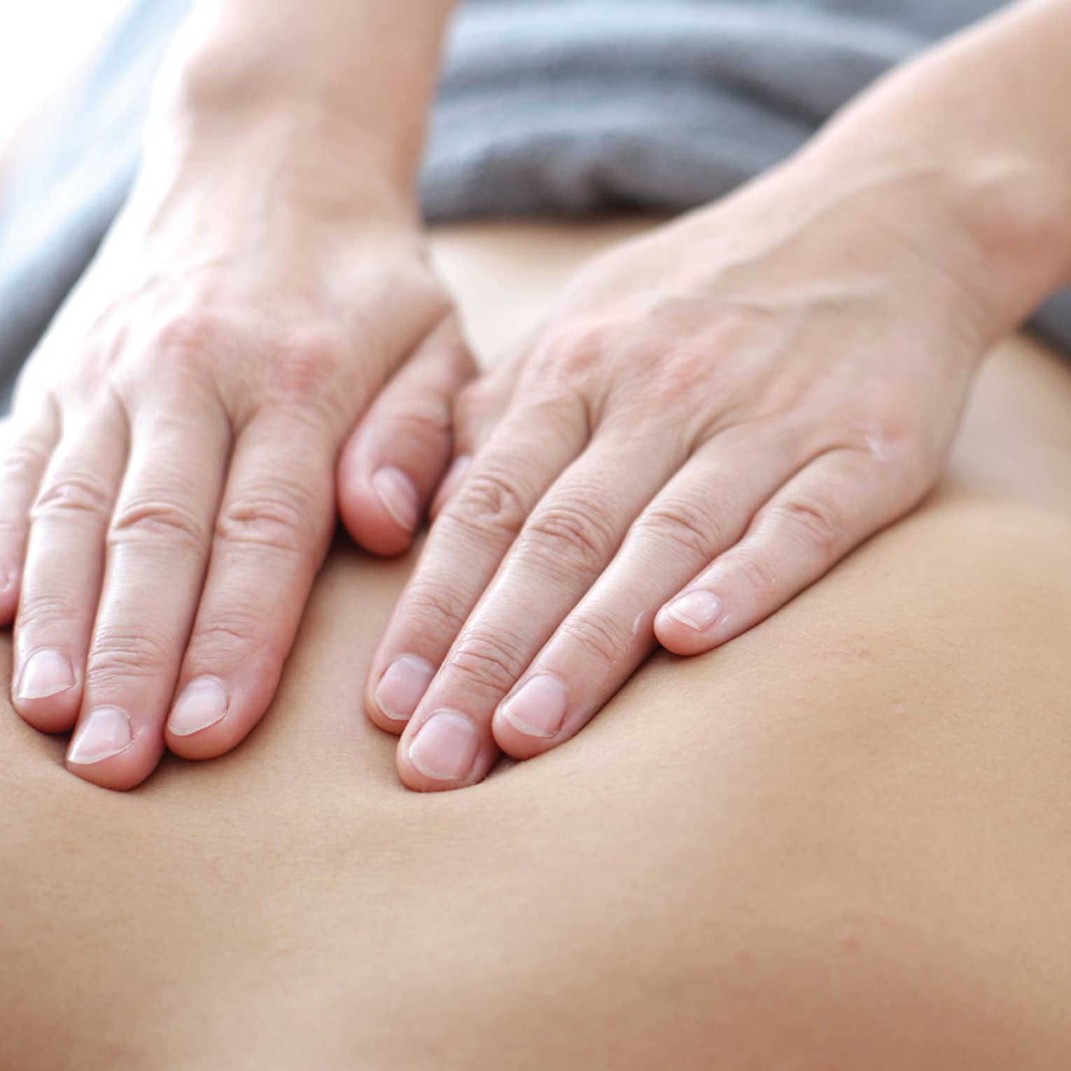 Hands massaging bare shoulders, back