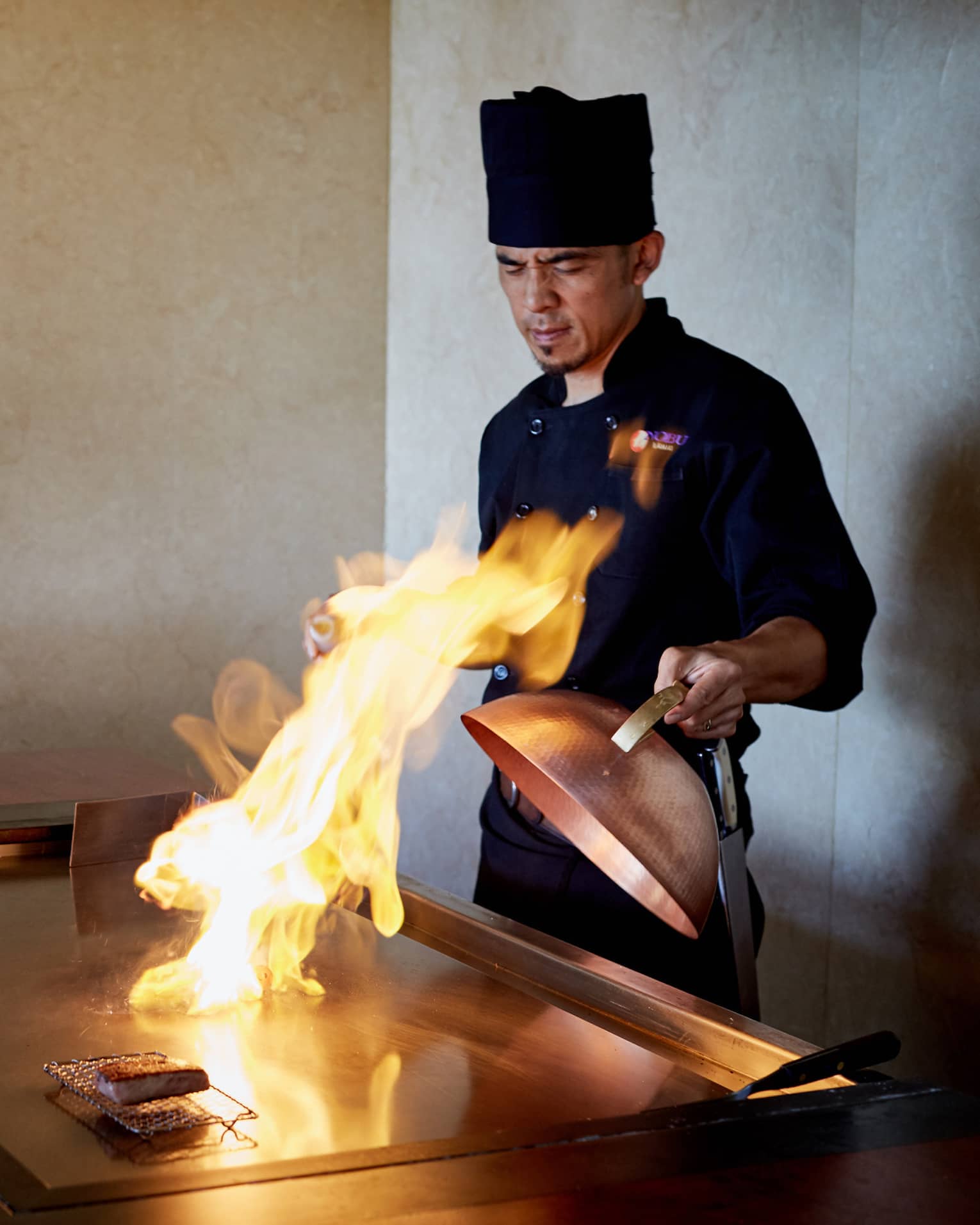 Flames shoot up from grill as NOBU restaurant chef pulls back copper lid