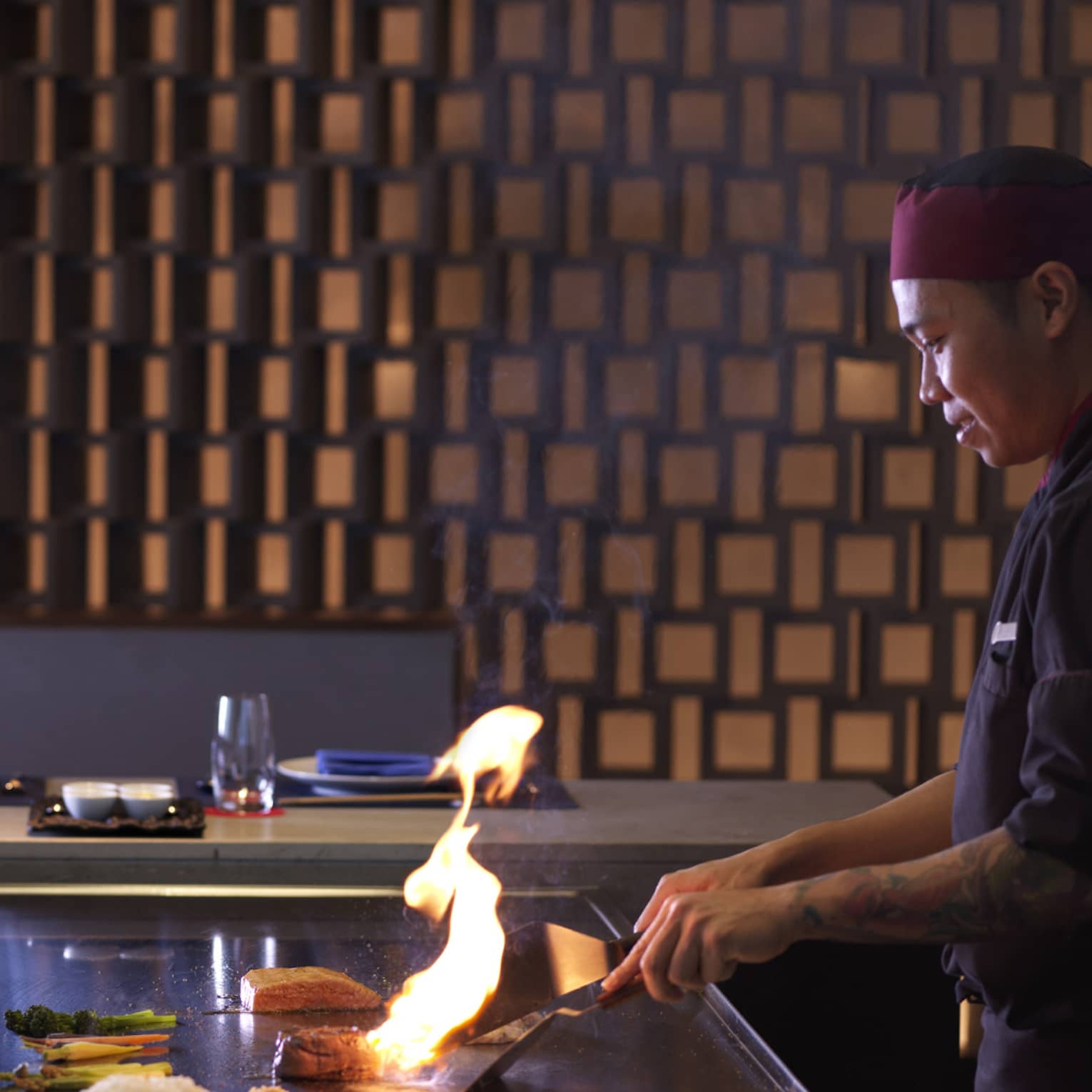 A chef works on a Schichirin with an open flame.