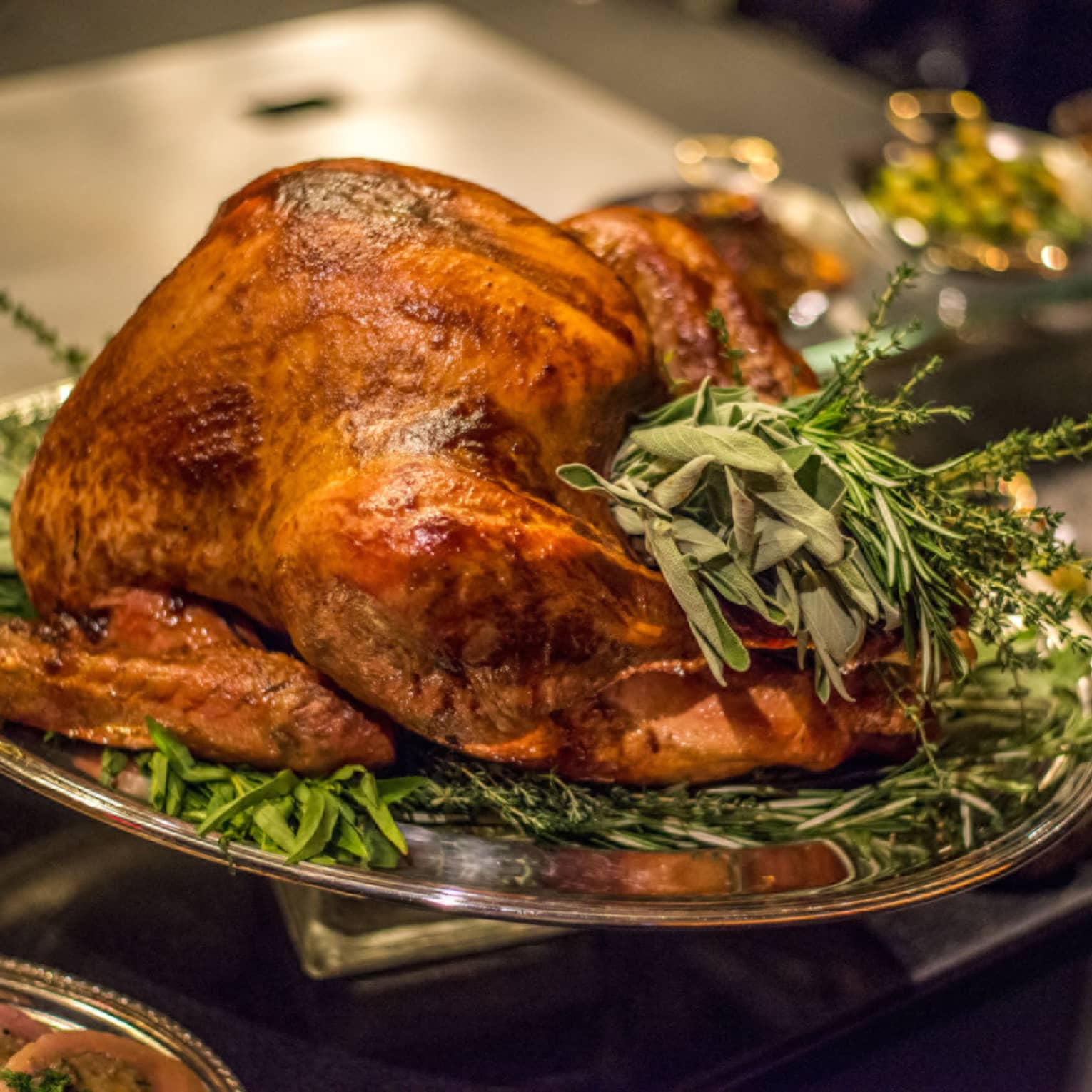 Roast turkey with fresh herbs on silver platter