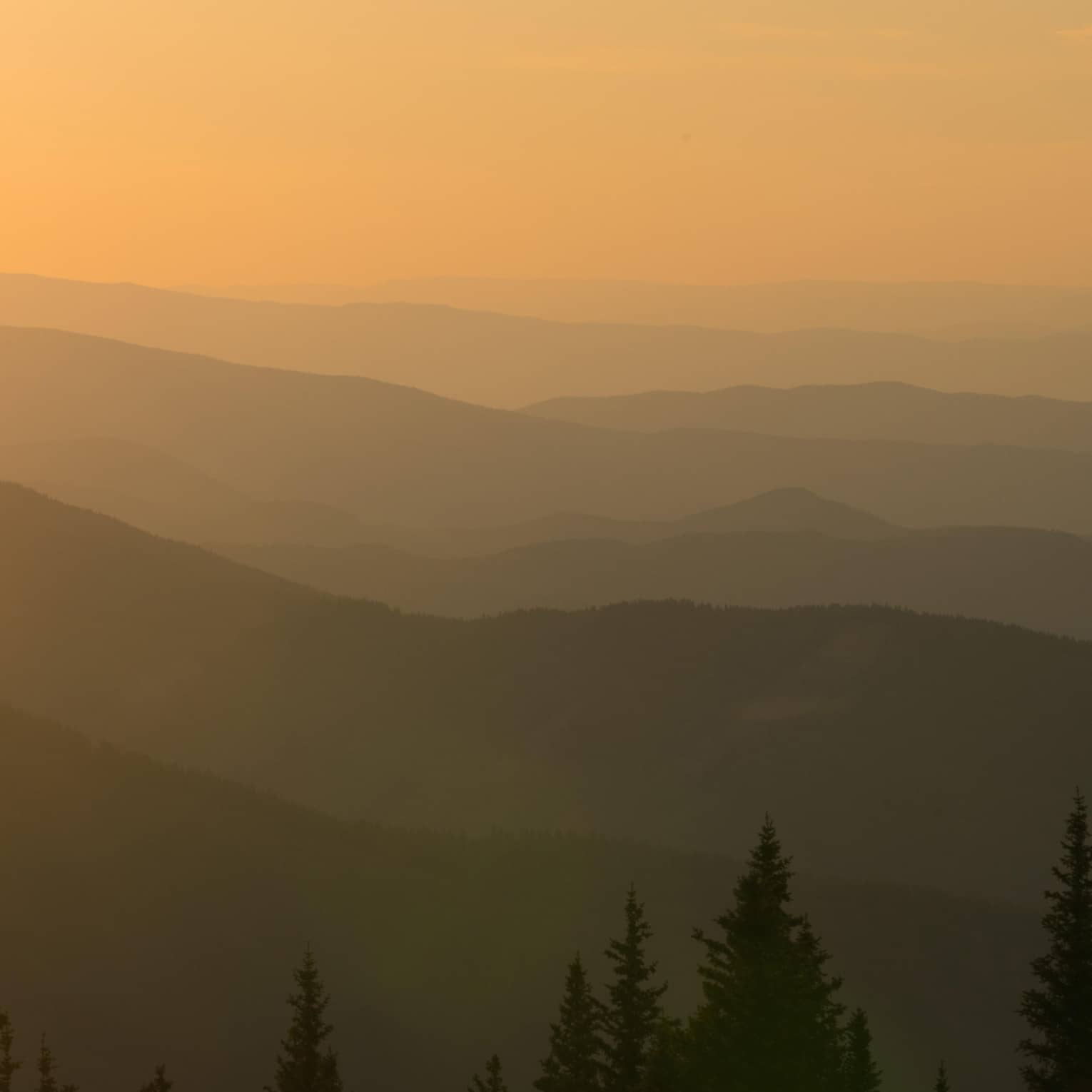 Helicopter at sunset flying over Aspen Mountain in the Elks Mountain range