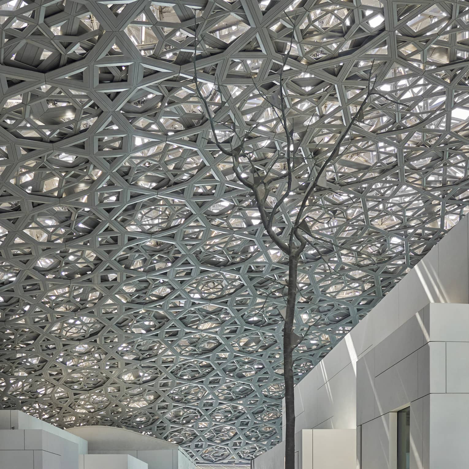 A large sculpture inside of a white stone building.