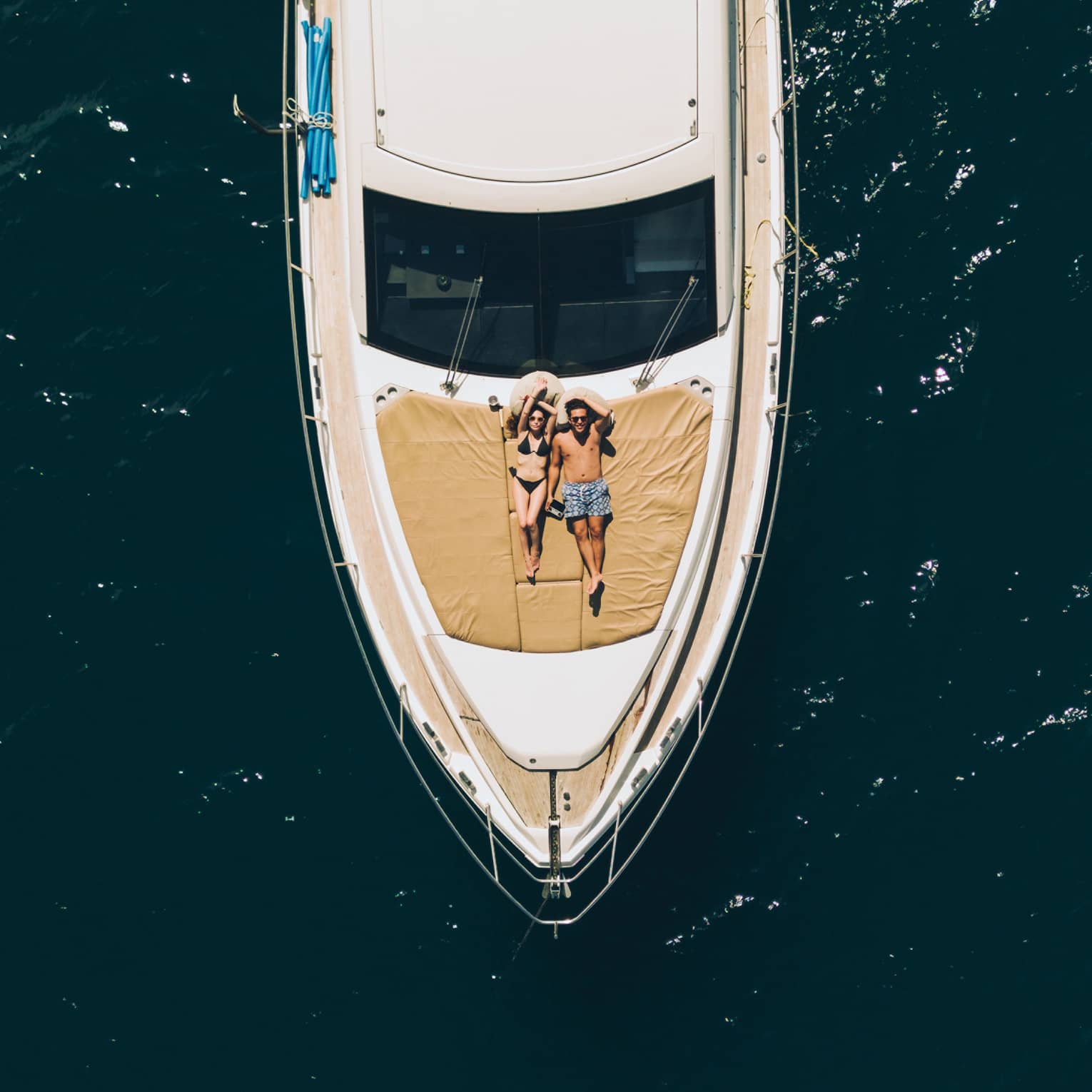 Aerial view of couple relaxing on the front of a large boat