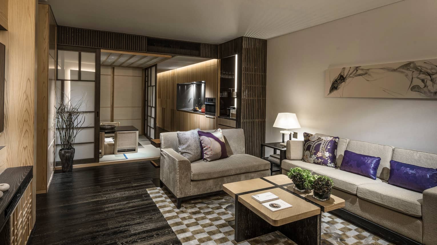 Dining residence with beige sofas, purple and beige cushions, kitchenette, coffee tables and traditional sliding doors leading to a tatami seating area