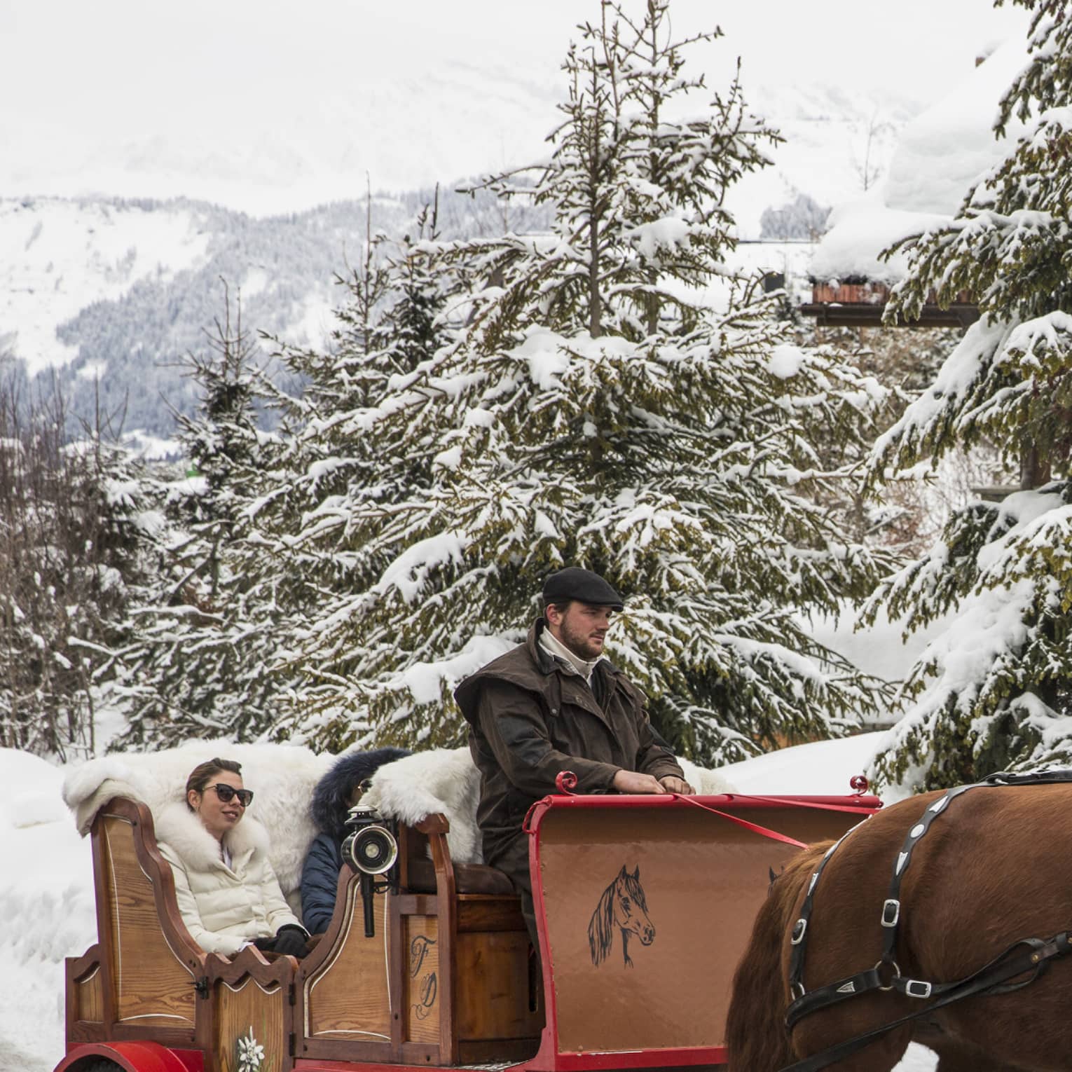 Guests explore a snow covered Megeve in a horse drawn carriage