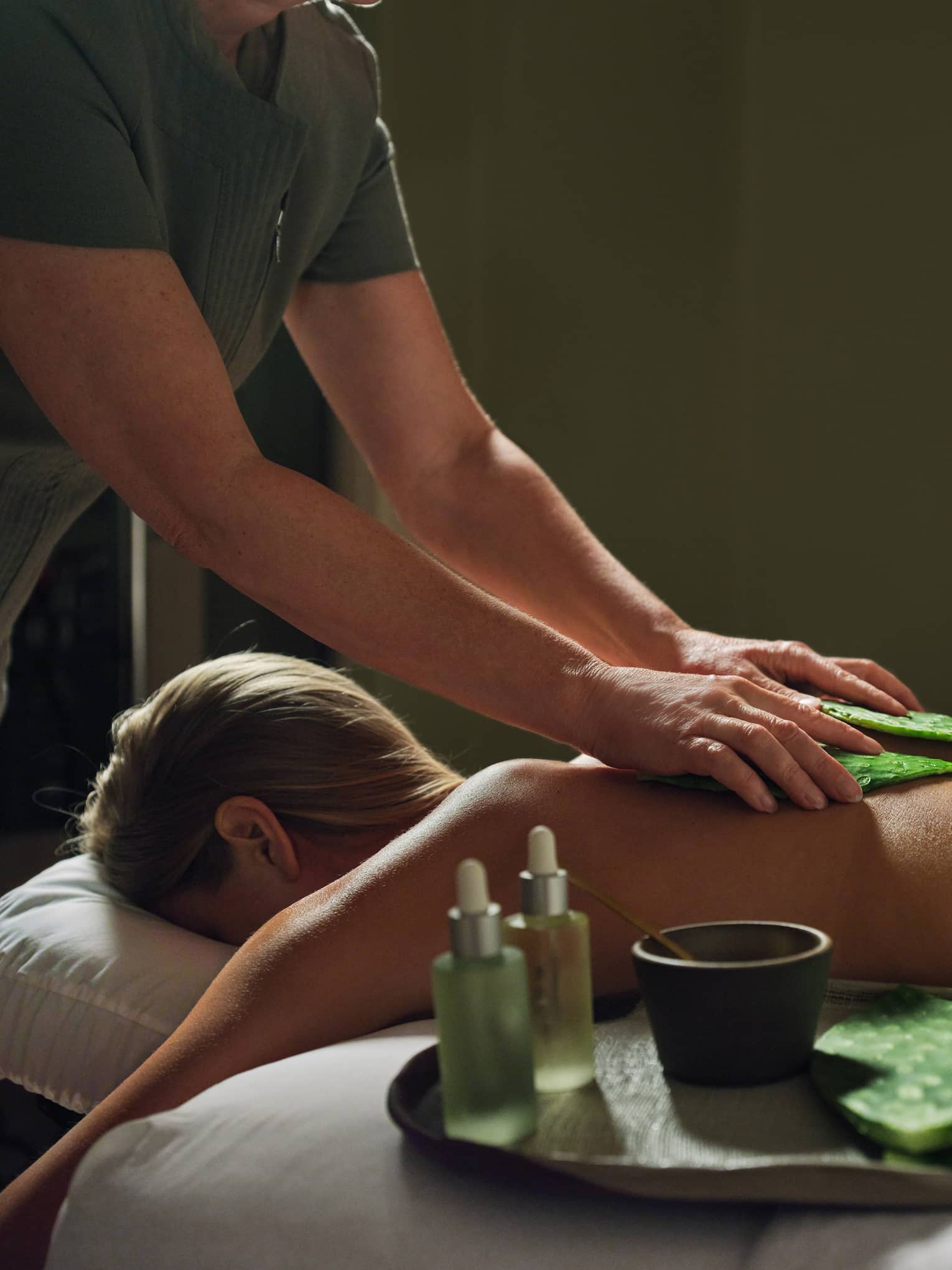 Guest laying on massage table with a blanket while getting a back massage.