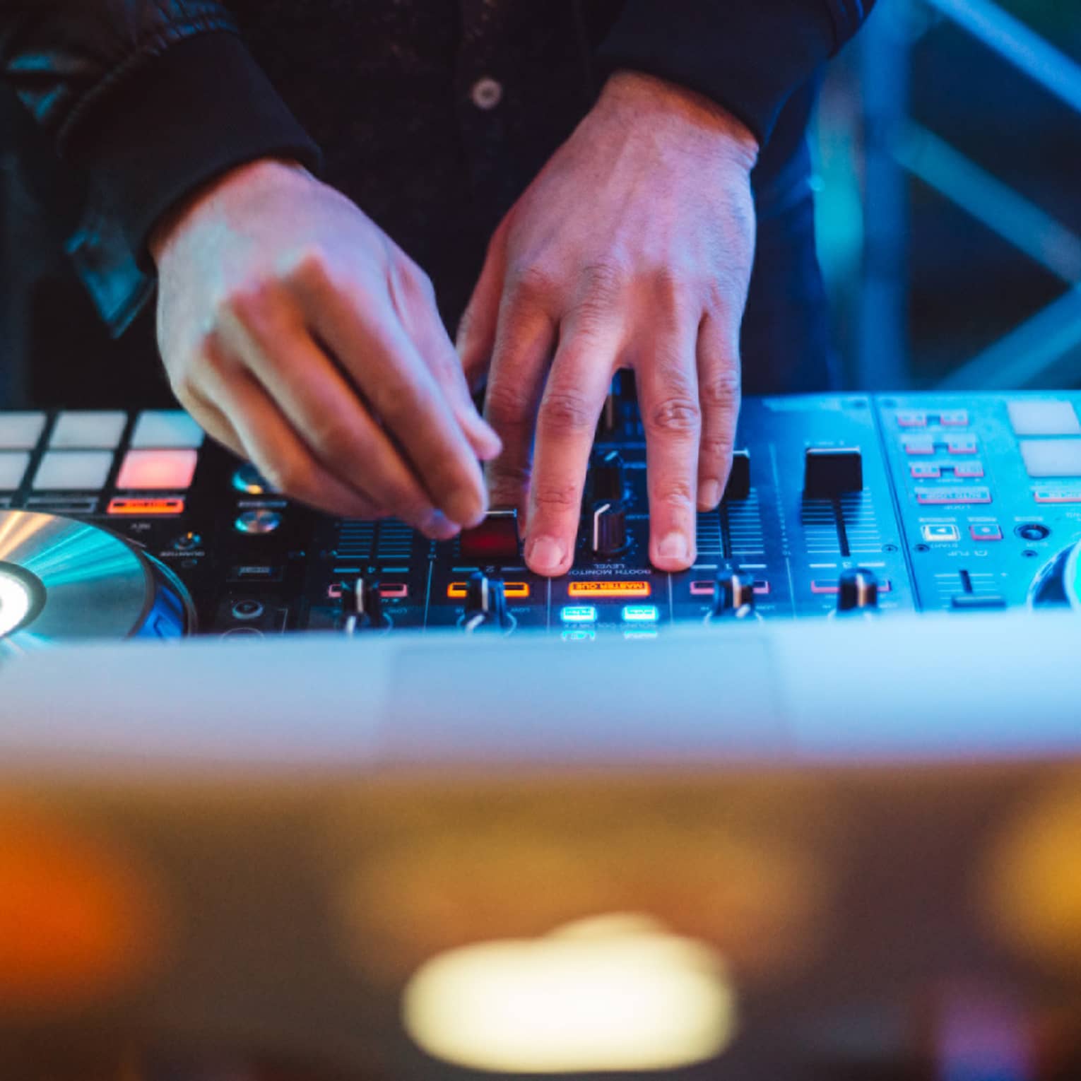 A DJ mixes music on a DJ mixer