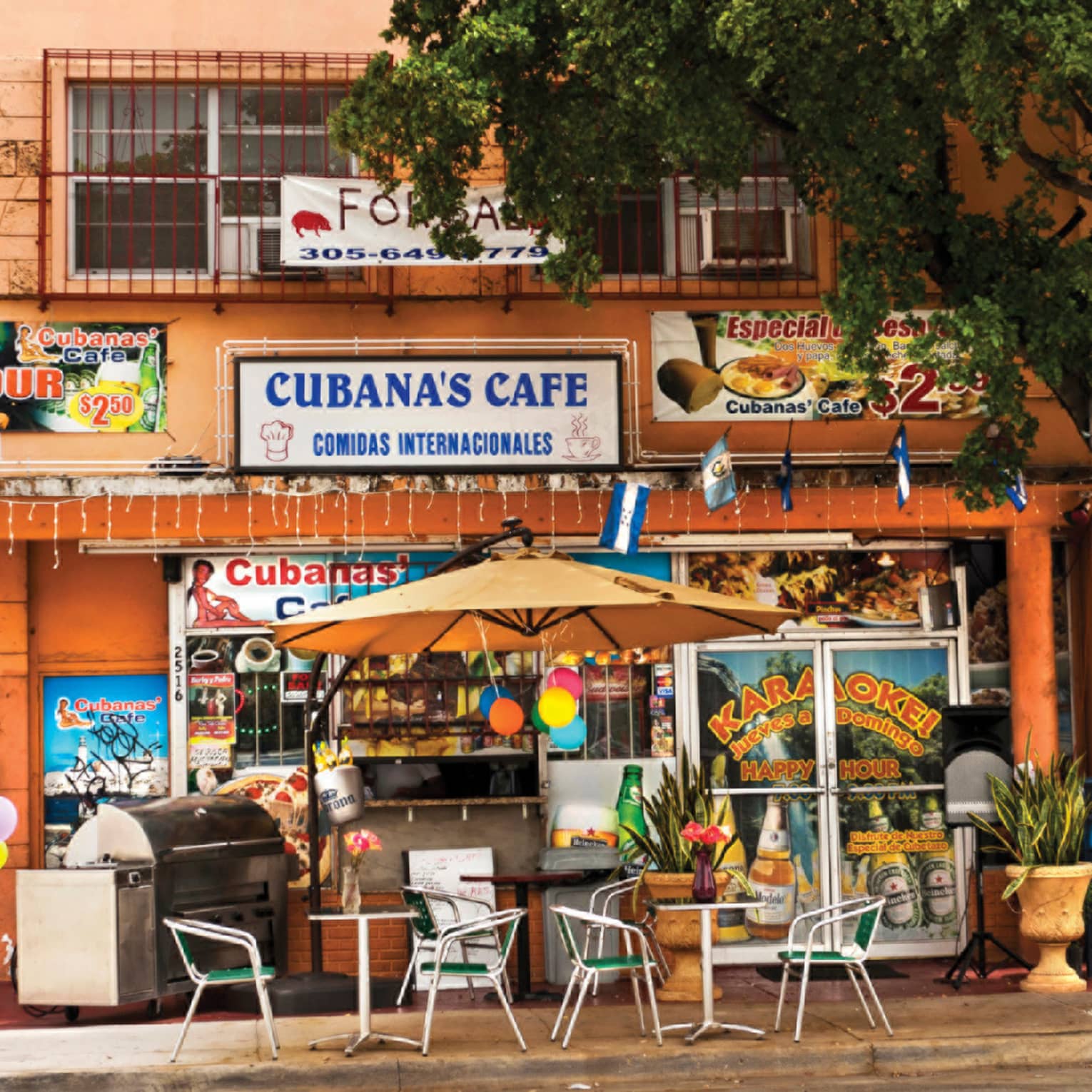 Exterior of colourful Cuban cafe with tables and chairs at Little Havana in the Calle Ocho