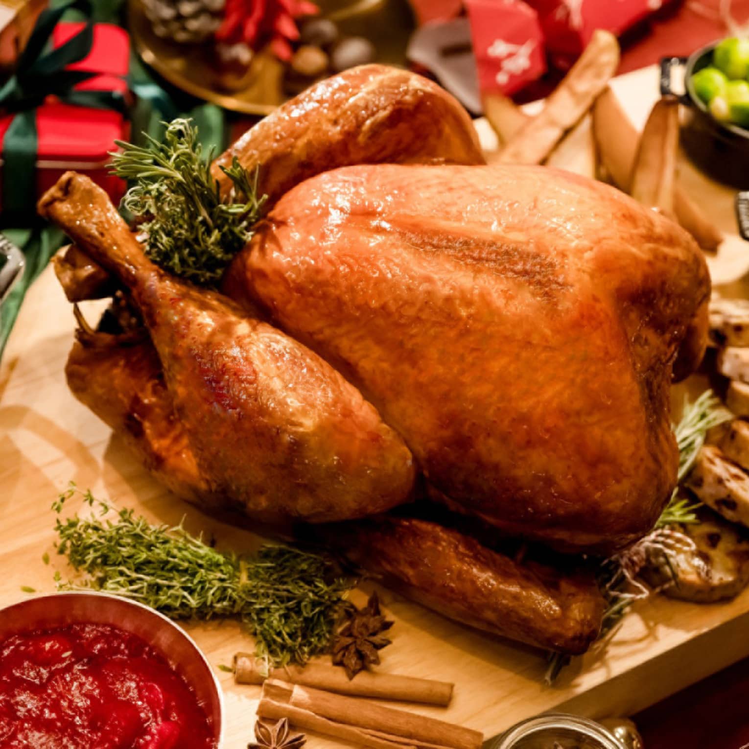 Slow-roasted turkey on carving board with accompaniments