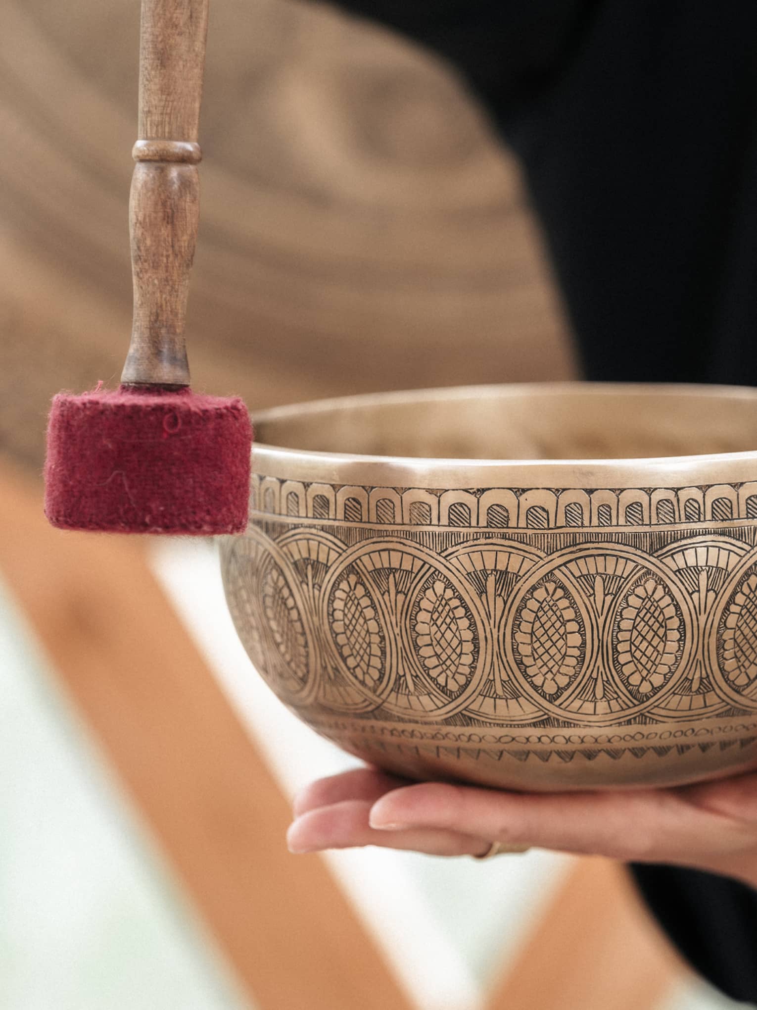 Person holding a gold engraved sound bath healing bowl