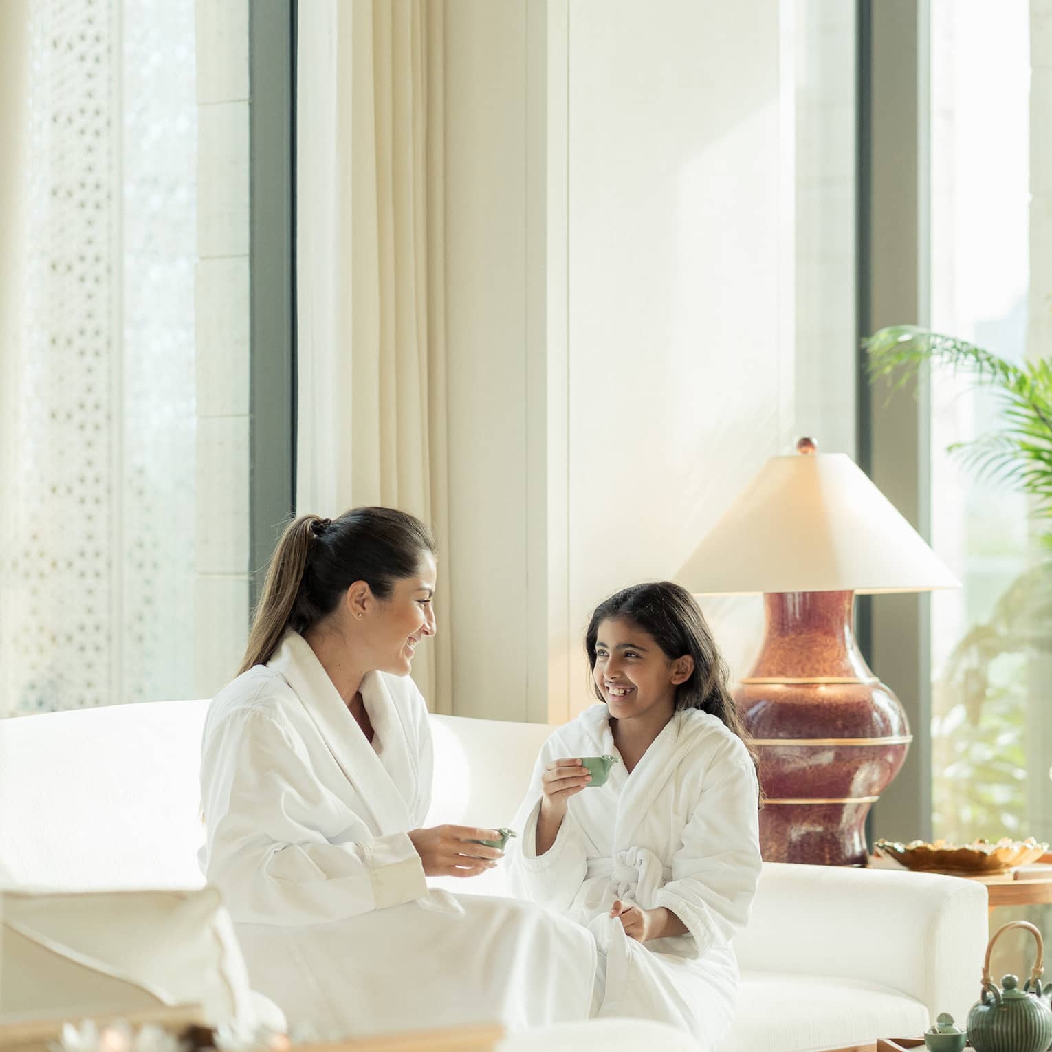 Mom and daughter enjoy tea in luxury hotel spa