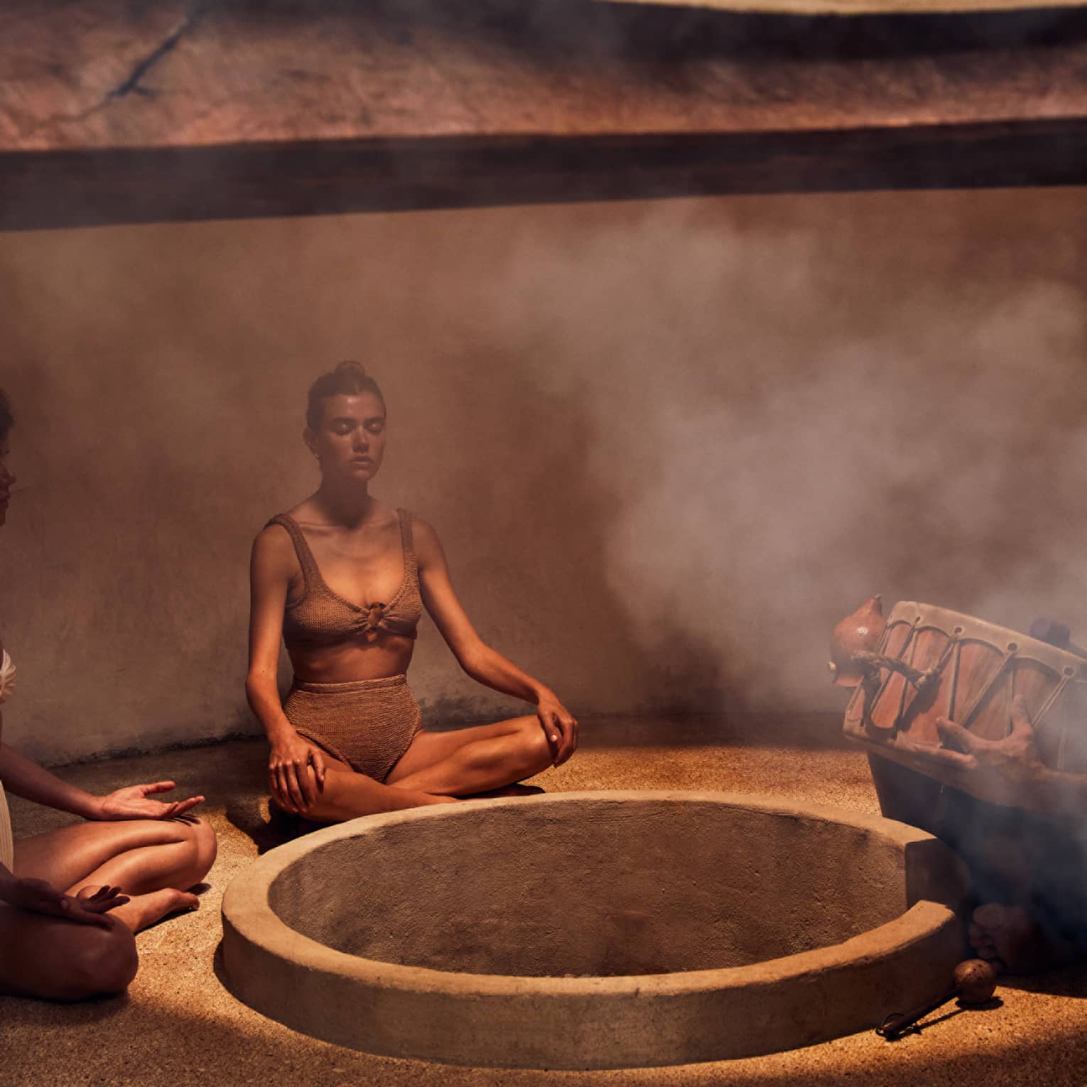 Three people sitting in a heated room with steam.