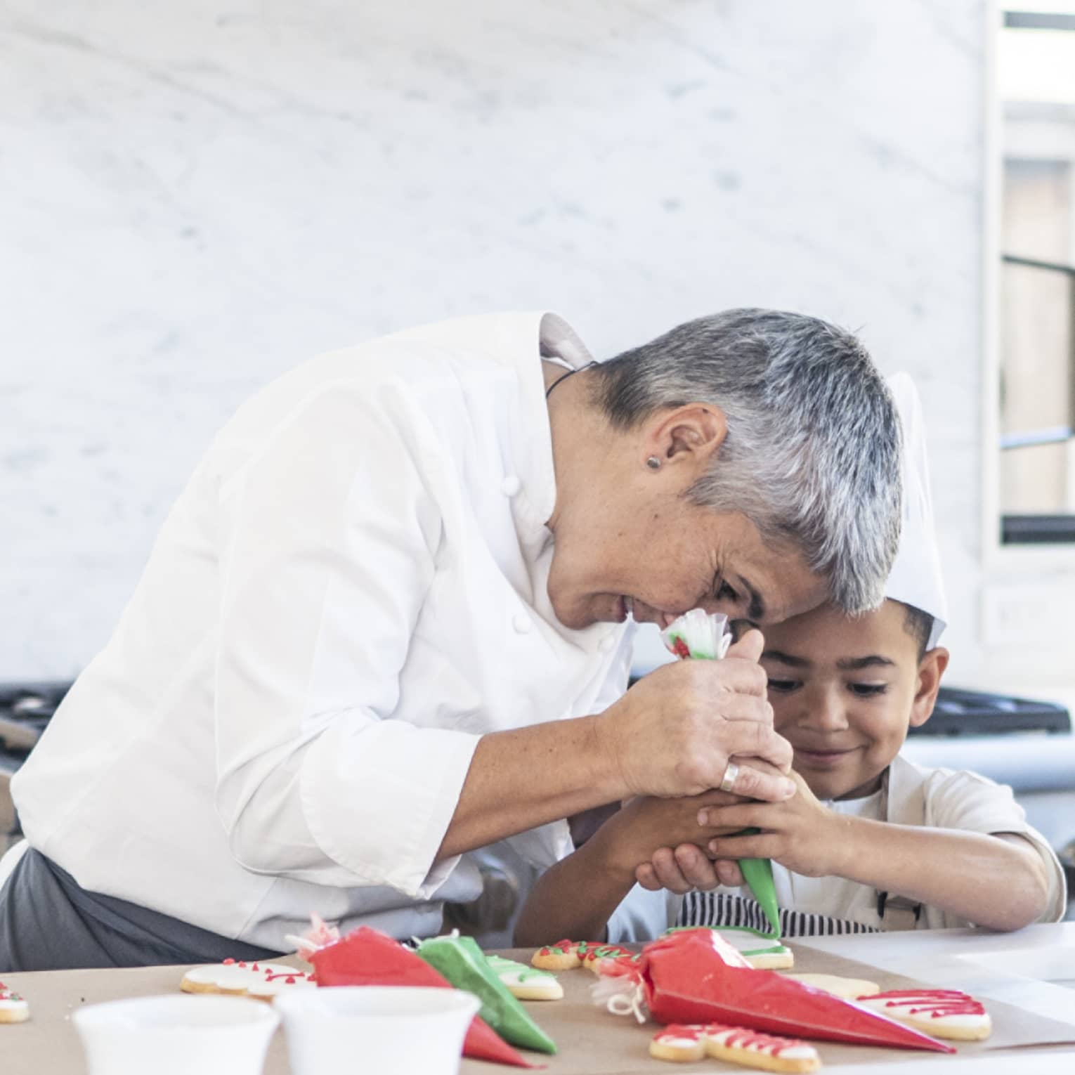 A chef and child decorating cookies.