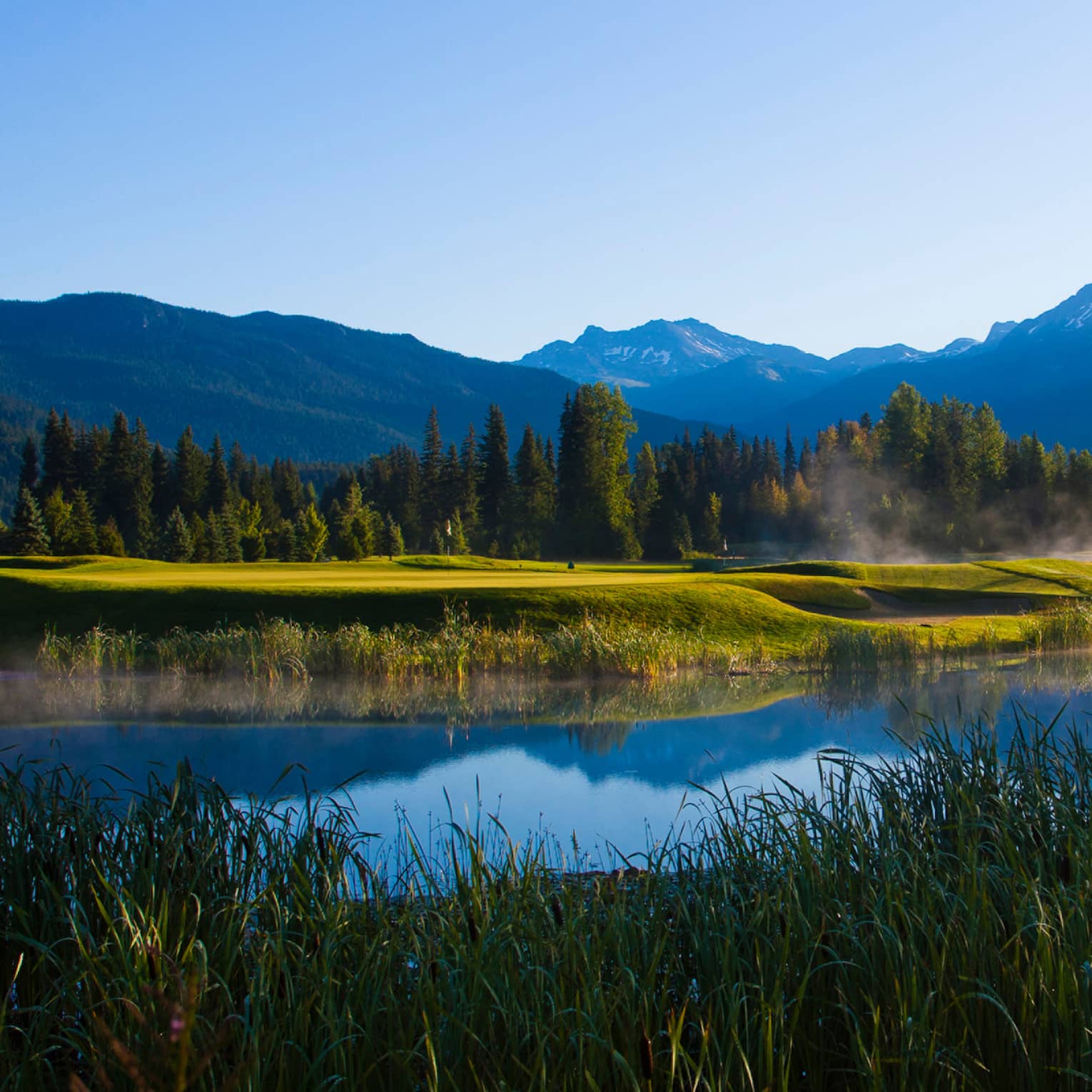Silhouettes of three people crossing misty river onto Nicklaus North Golf Course