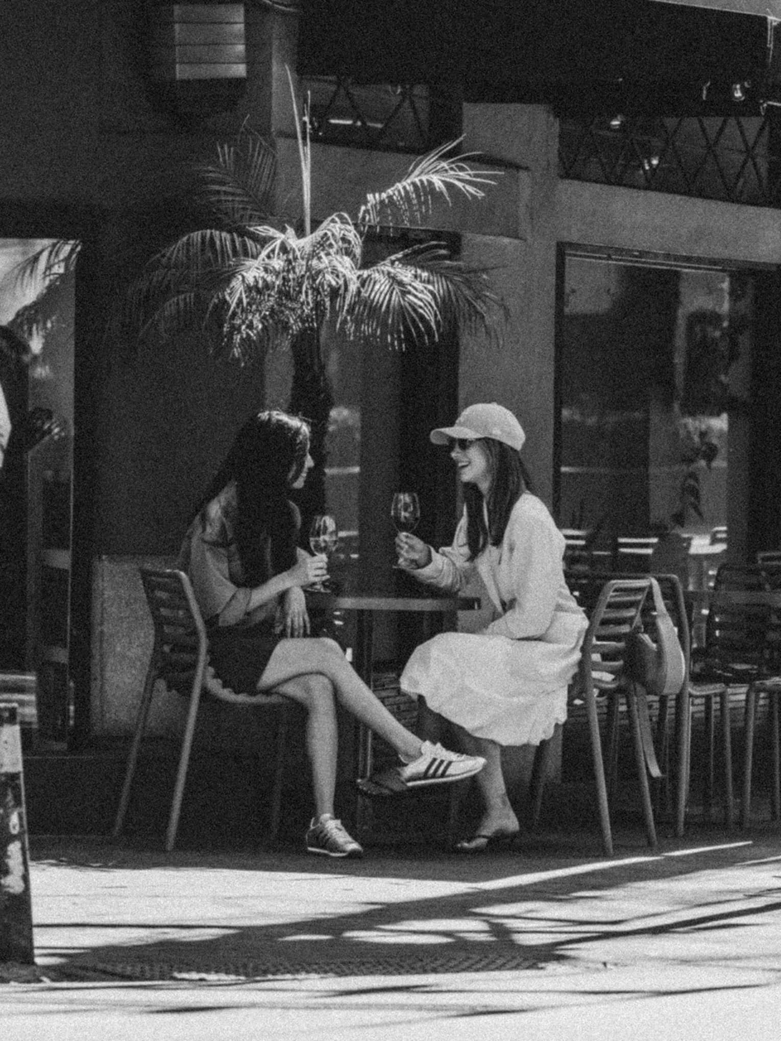 Two people sitting at an outdoor cafe on a city street