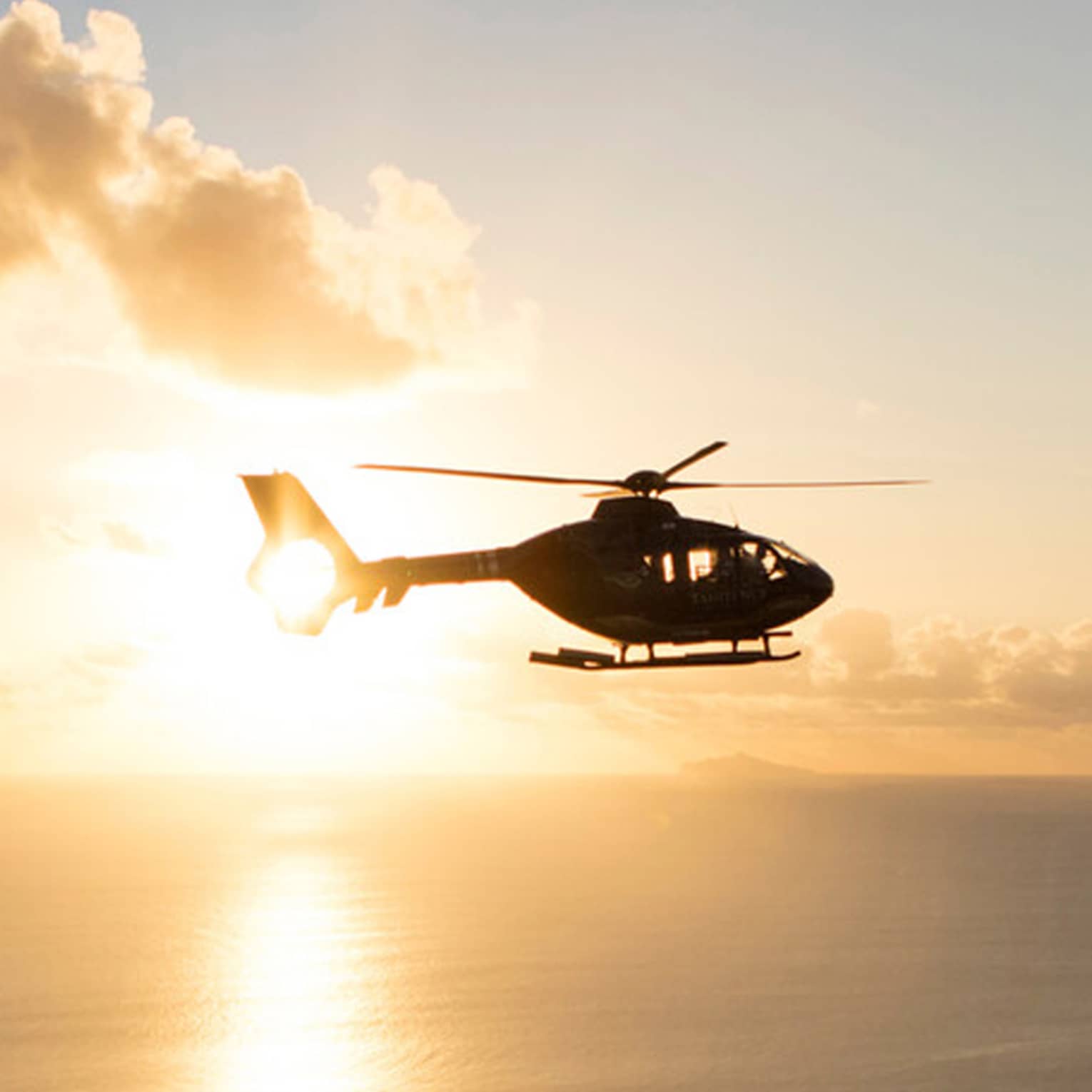 Helicopter over the sea at sunset