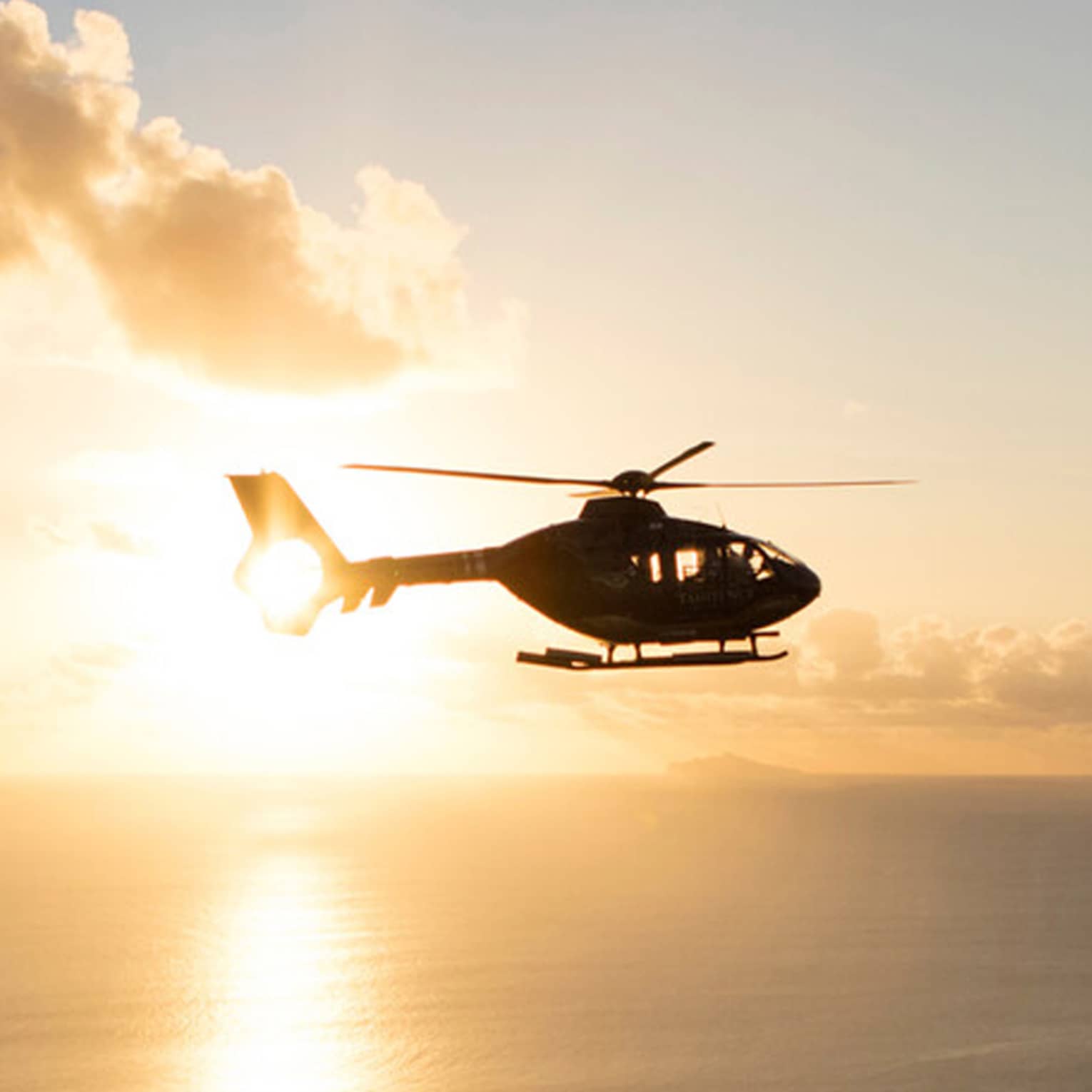 Helicopter over the sea at sunset