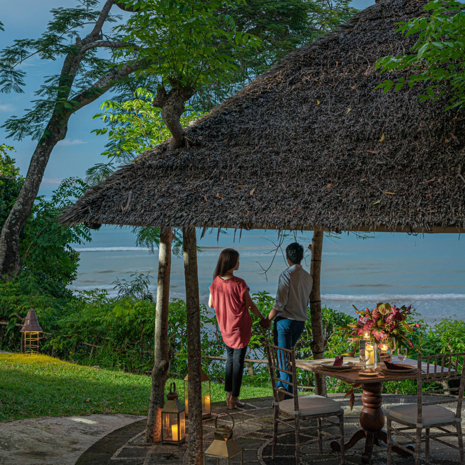 A couple enjoys a private outdoor dinner at dusk