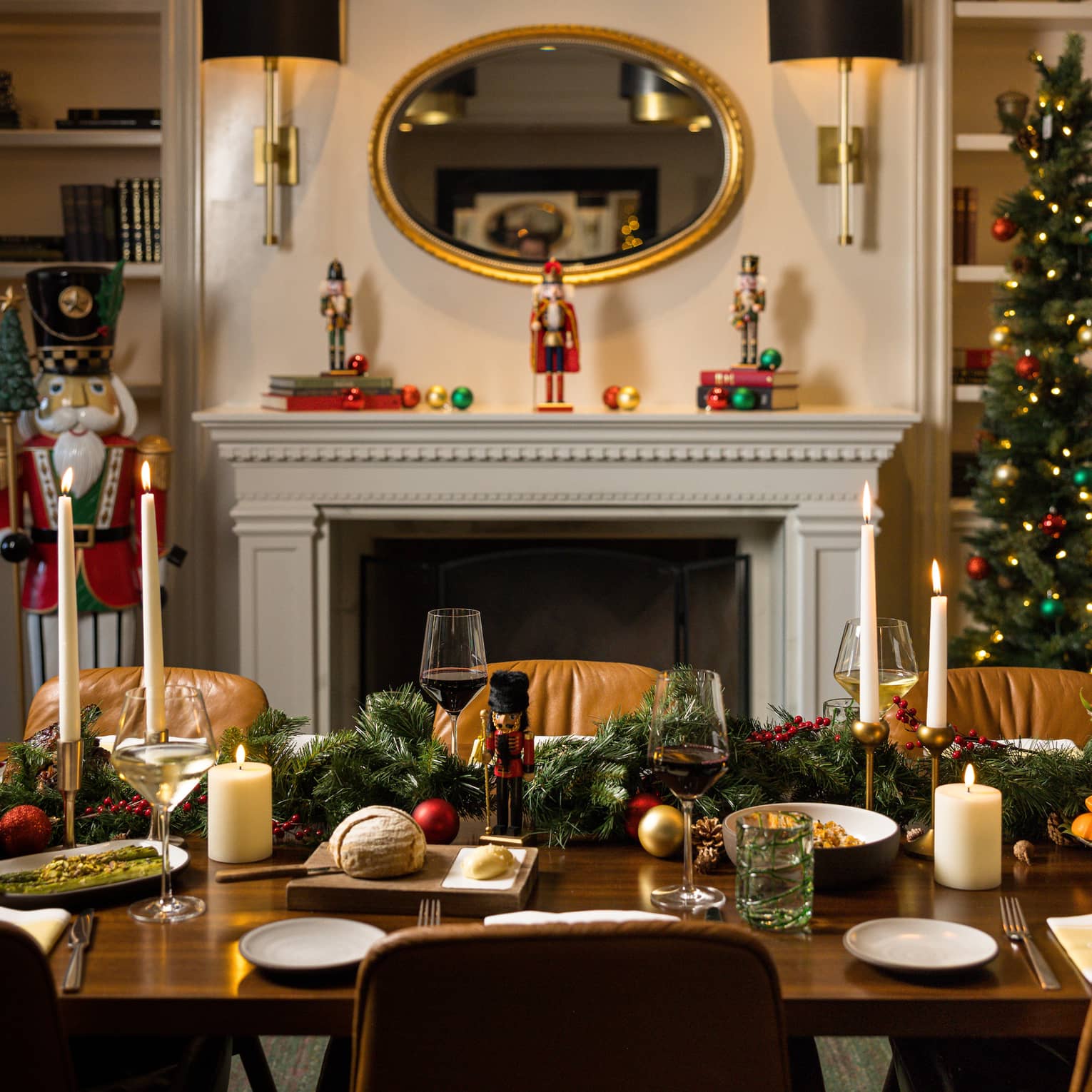 Table set infront of a fireplace and bookshelves is decorated for a holiday dinner