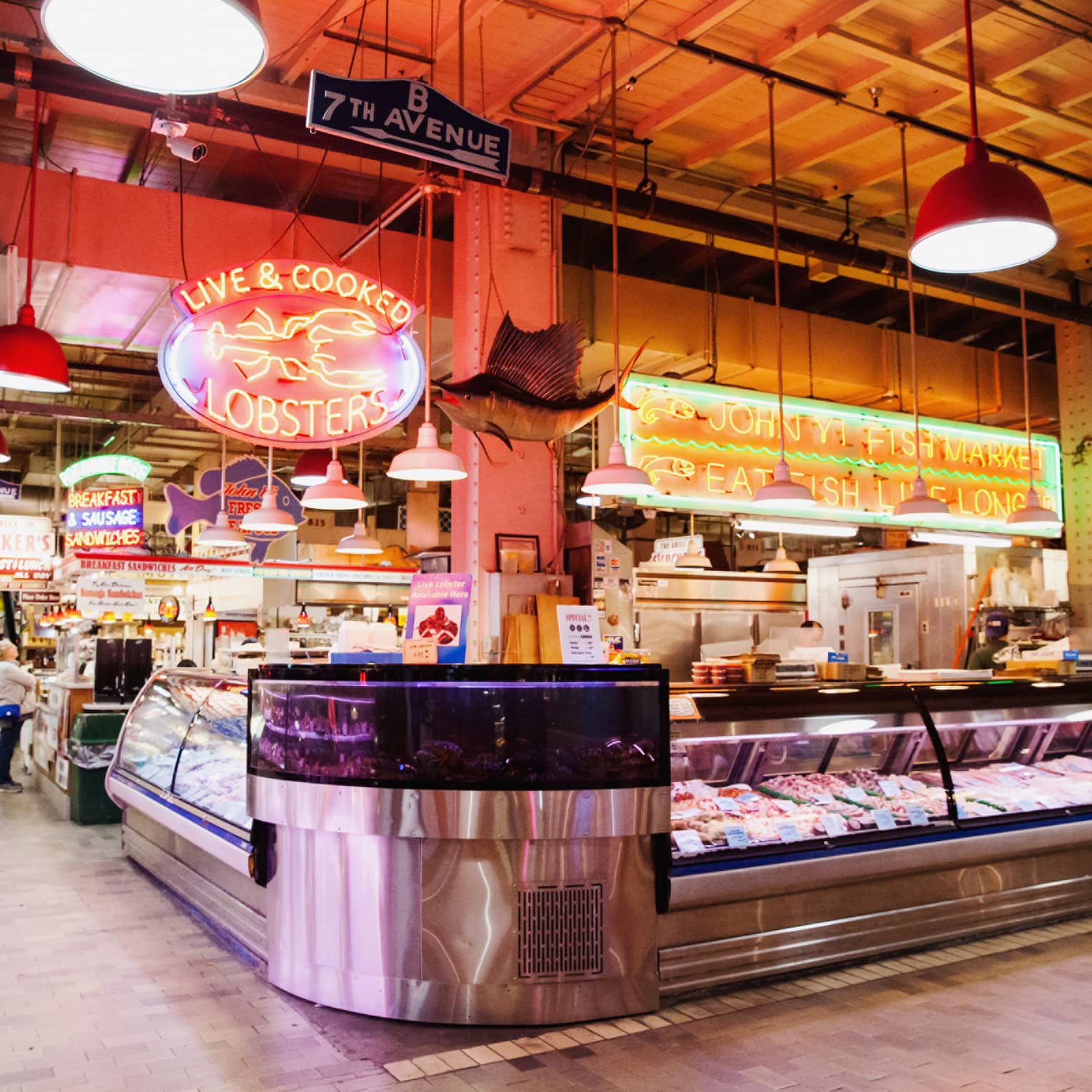A large indoor market featuring fresh seafood behind glass windows.