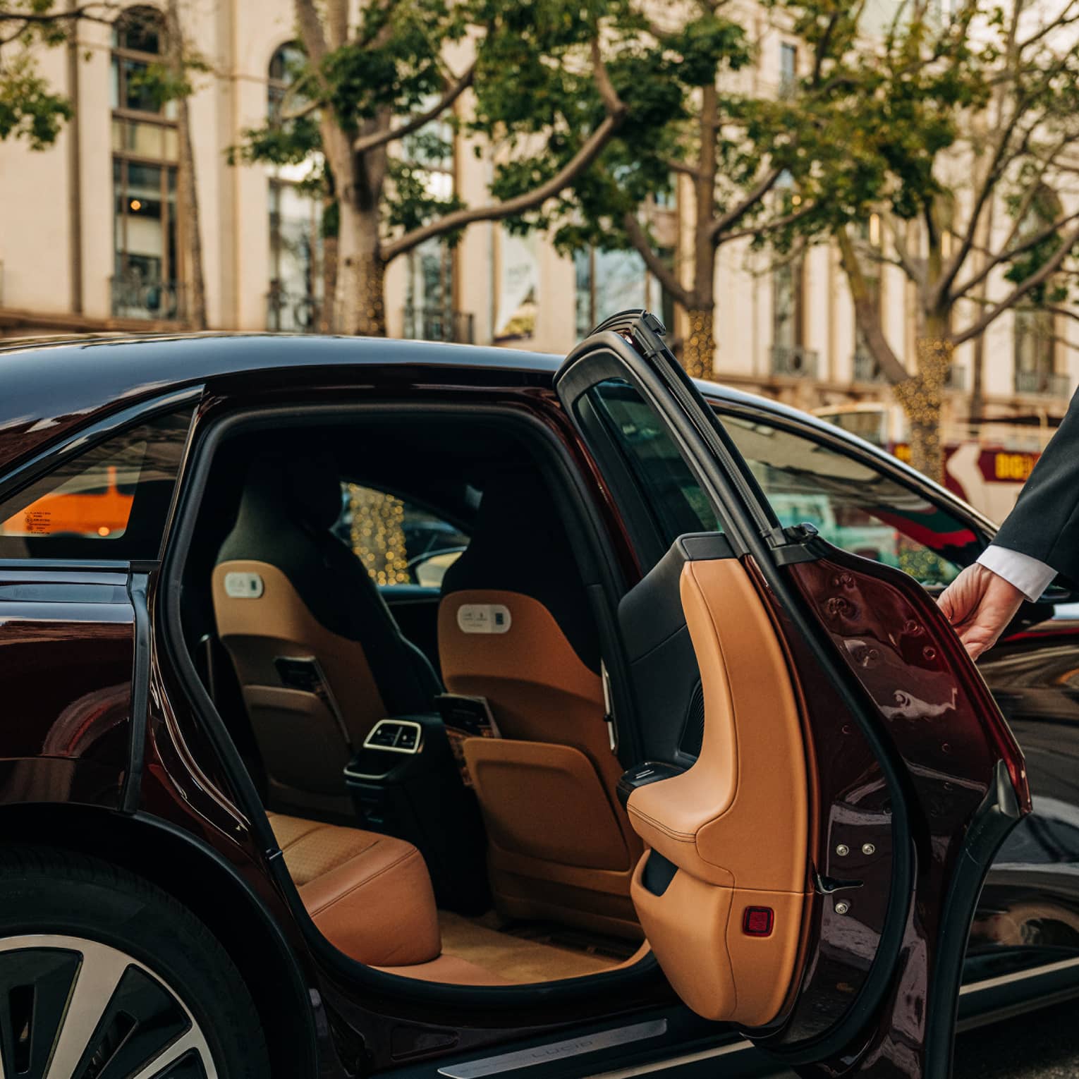 Person wearing a suit and opening a car door