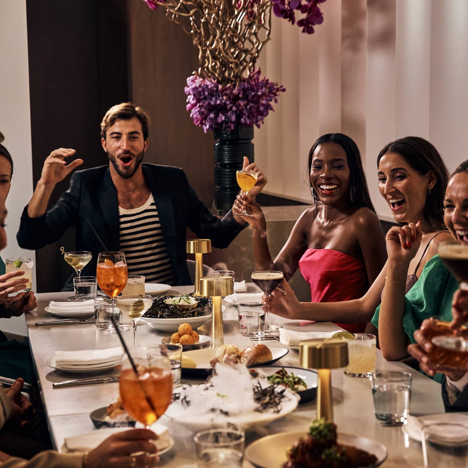 Friends enjoy a Friendsgiving around a long table