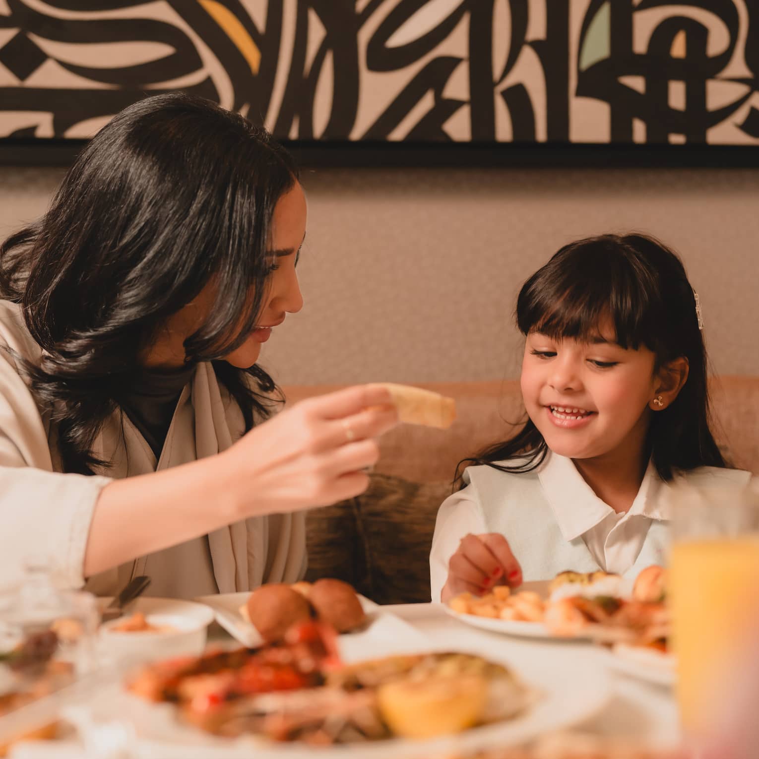 A parent and child enjoy an in-room dining meal