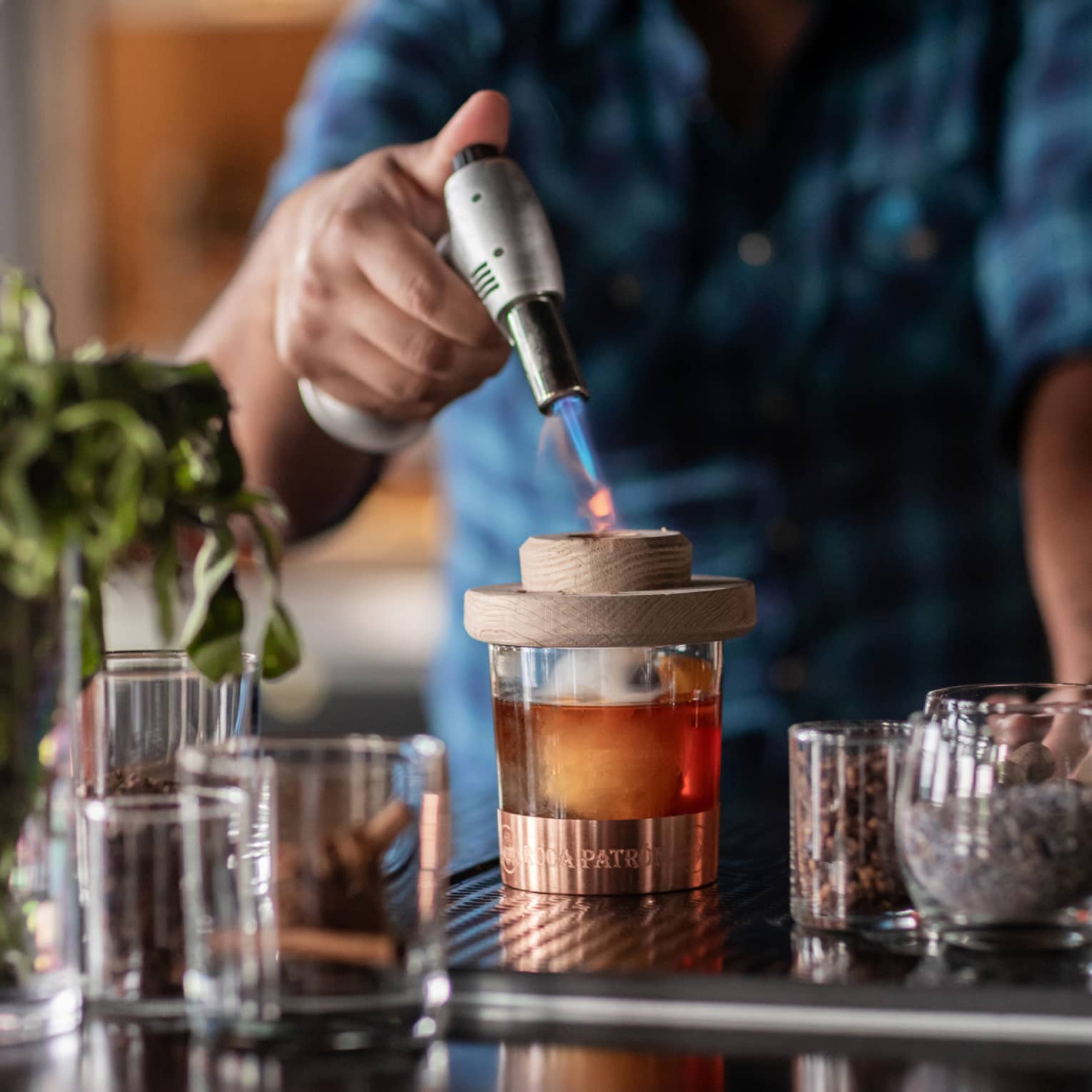 Bartender standing at the bar and using a whiskey torch to make a drink