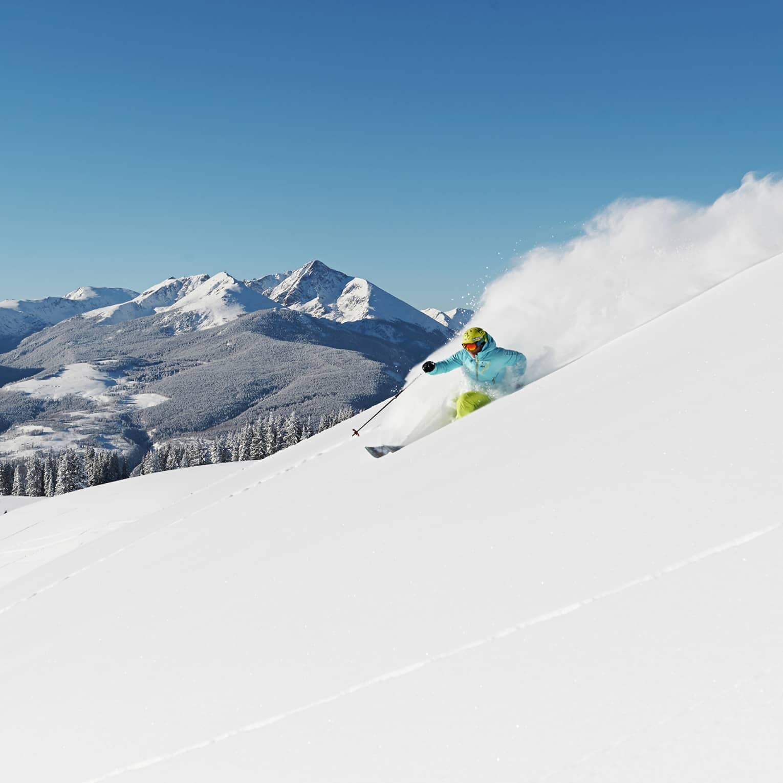 Person skiing down snow covered mountain top