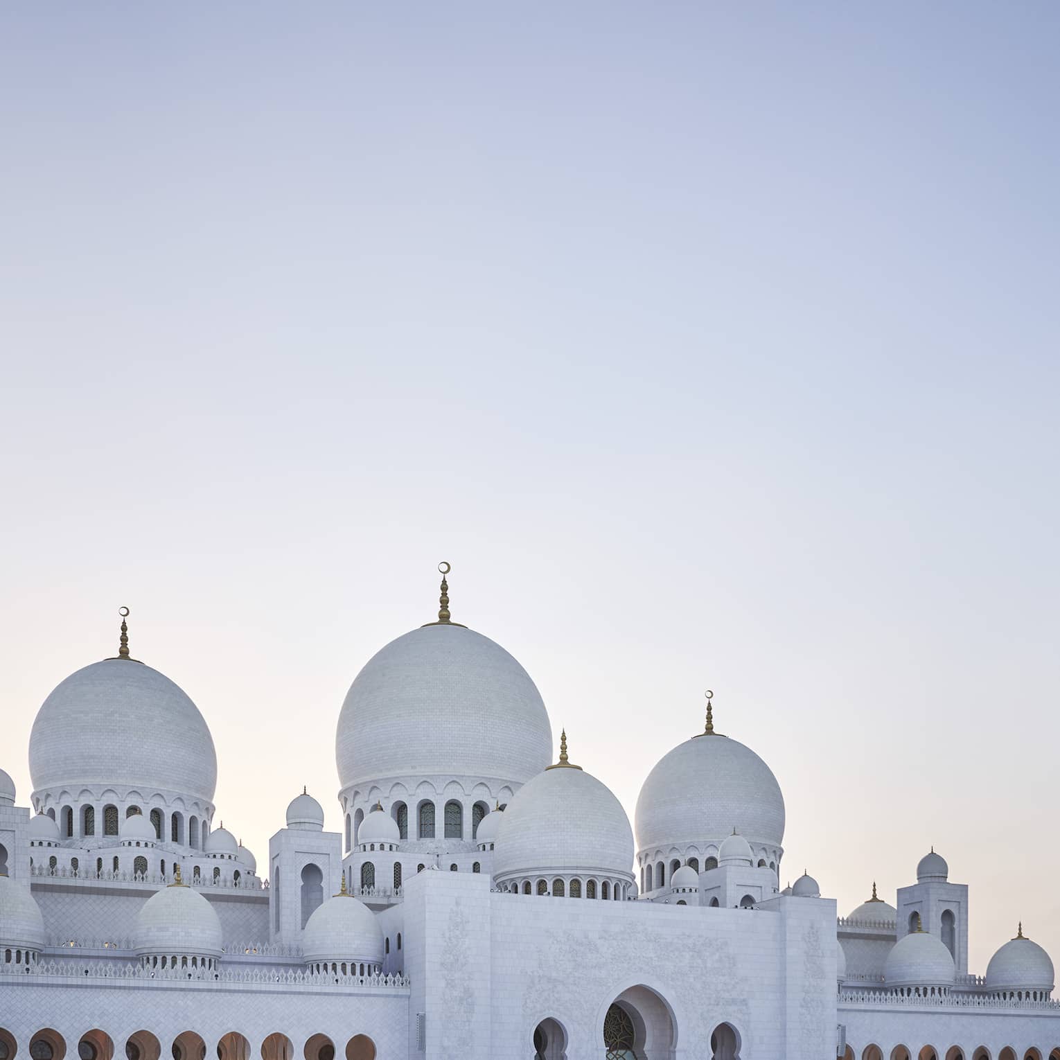 A large white mosque with two pillars made of marble.
