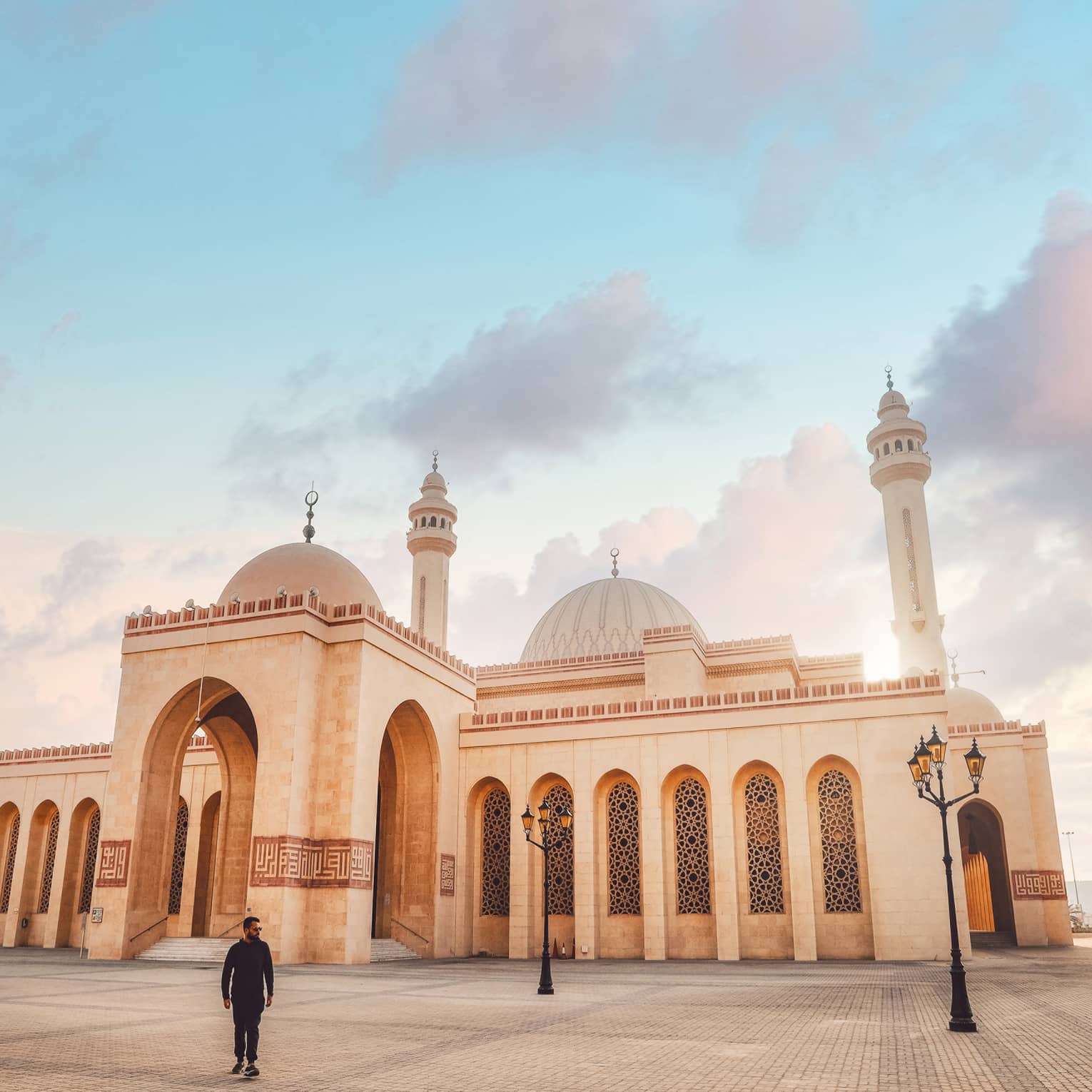 A large tan mosque with several pillars.