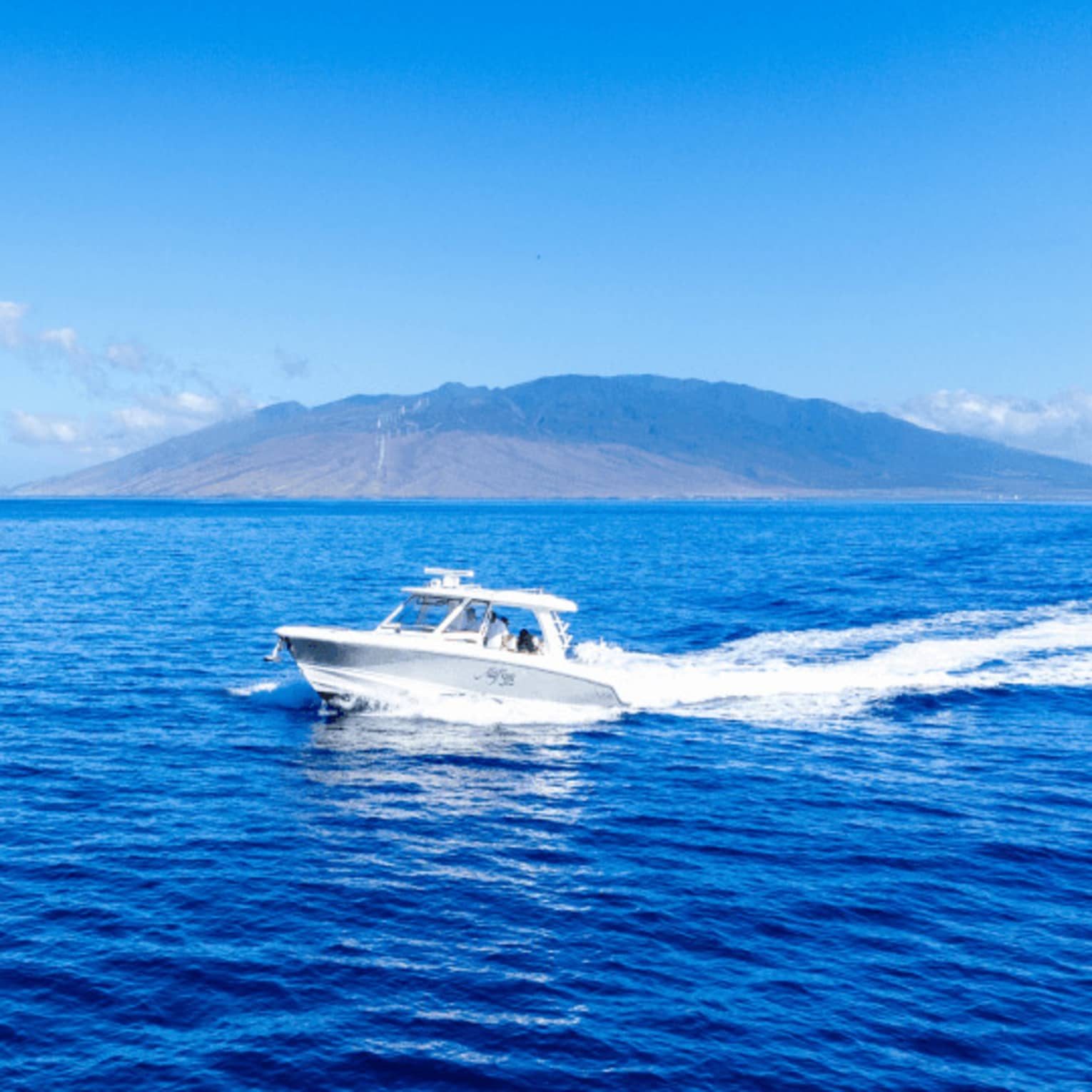 A boat on the water with island in the background