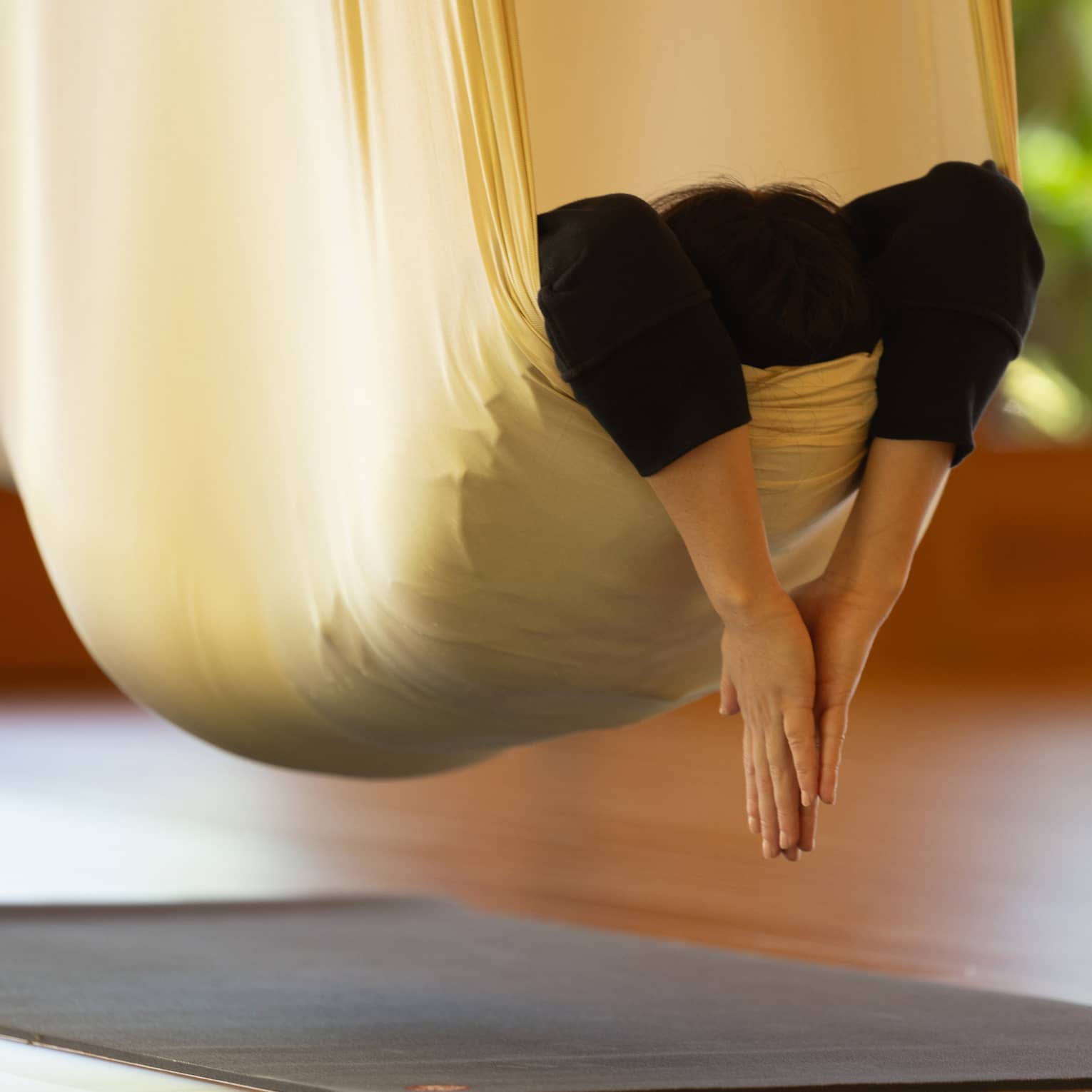 A person practicing hanging yoga.