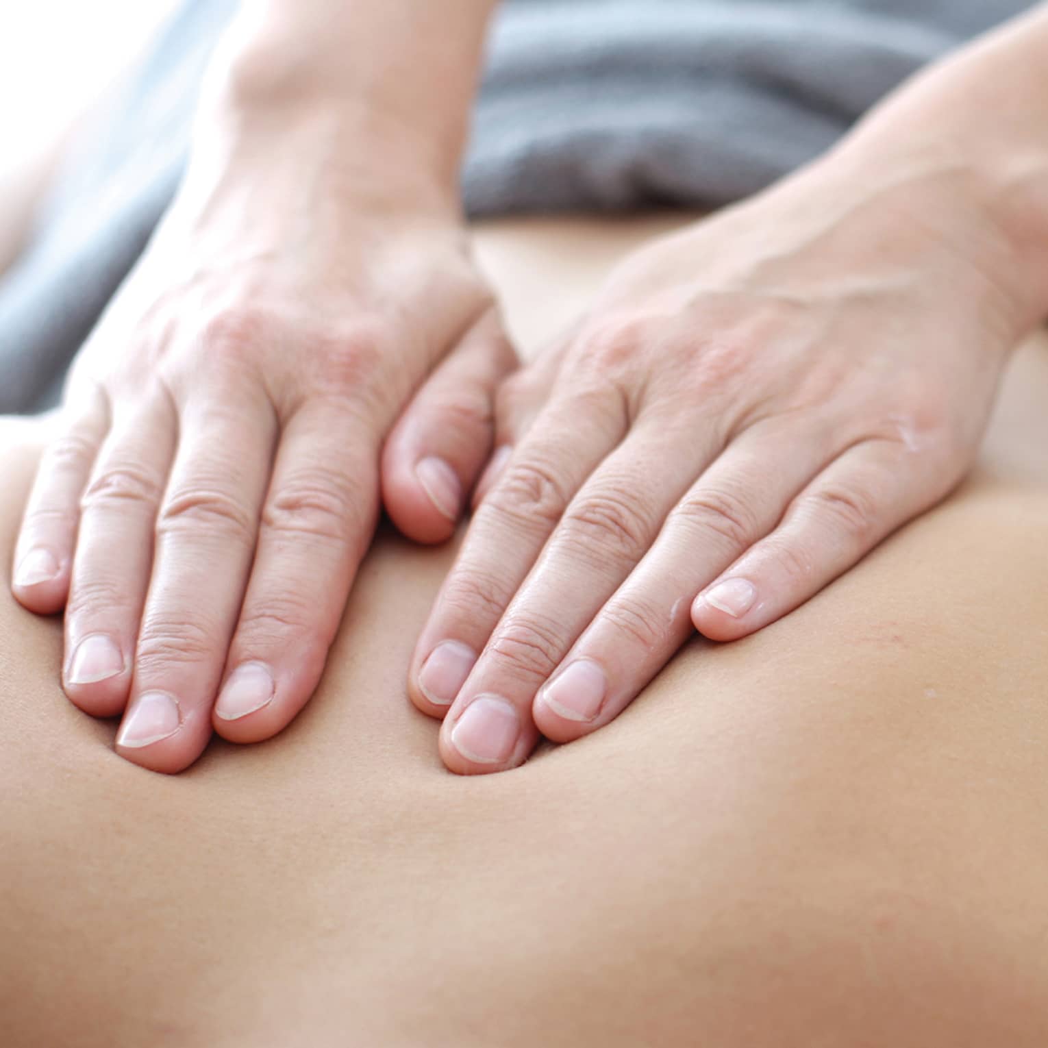 Hands massaging bare shoulders, back