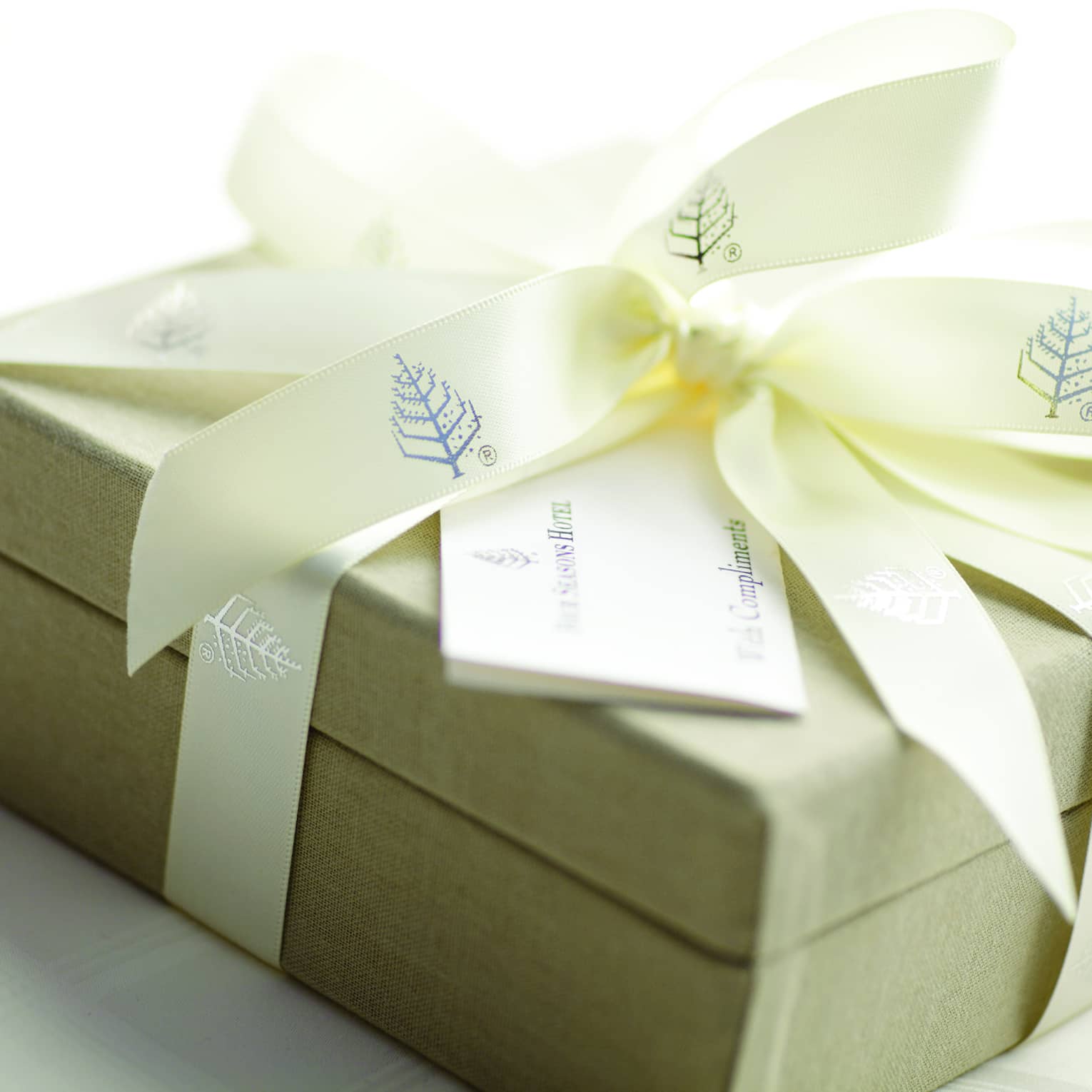 Gift box wrapped up with Four Seasons branded ribbon with a card