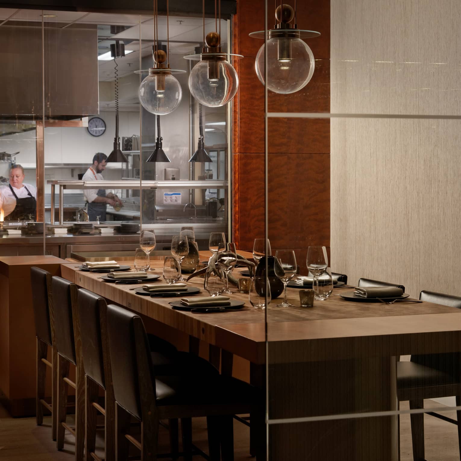 A large dining table next to an open kitchen.