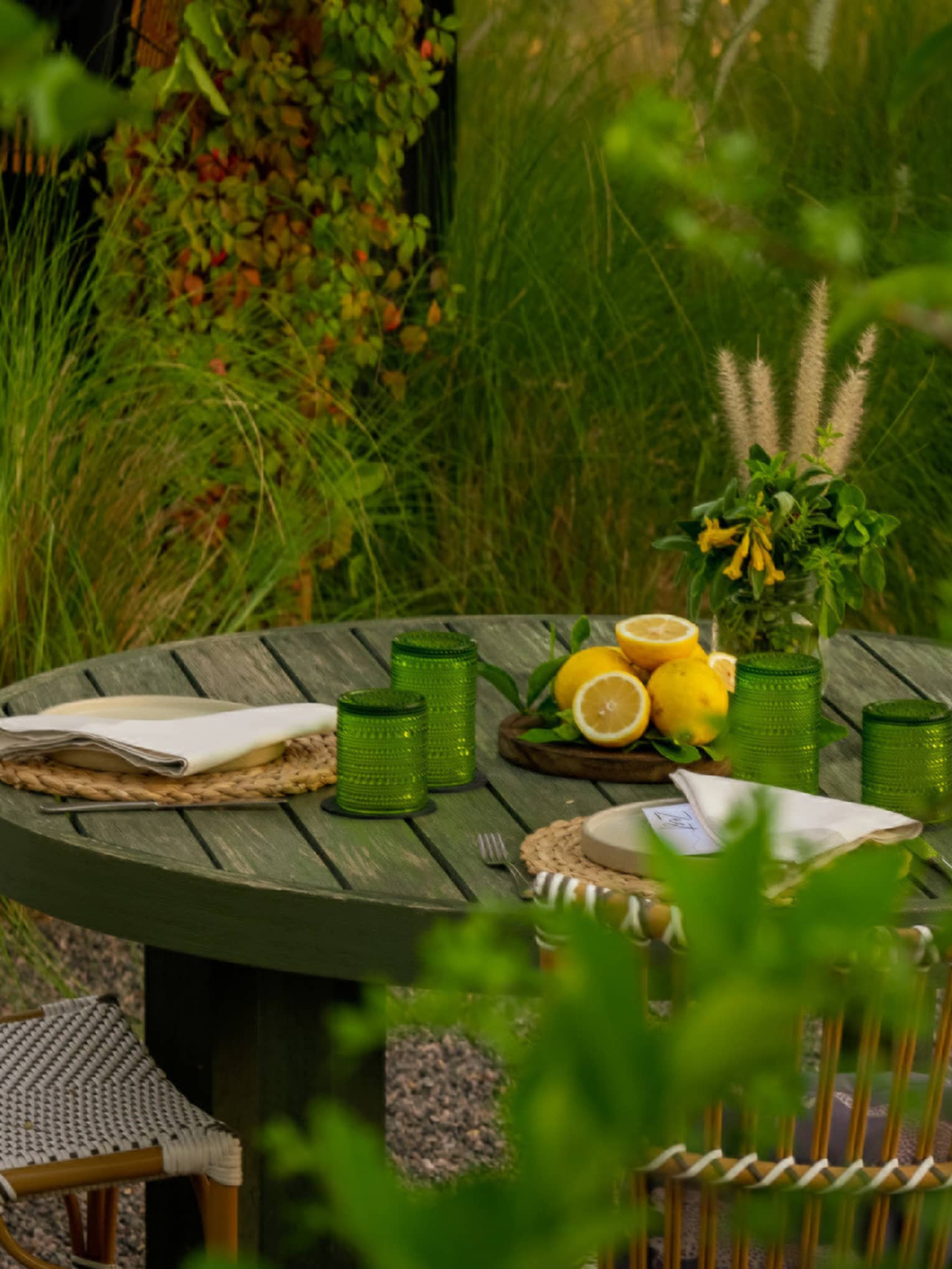 A round wooden table for two tucked in an intimate garden setting